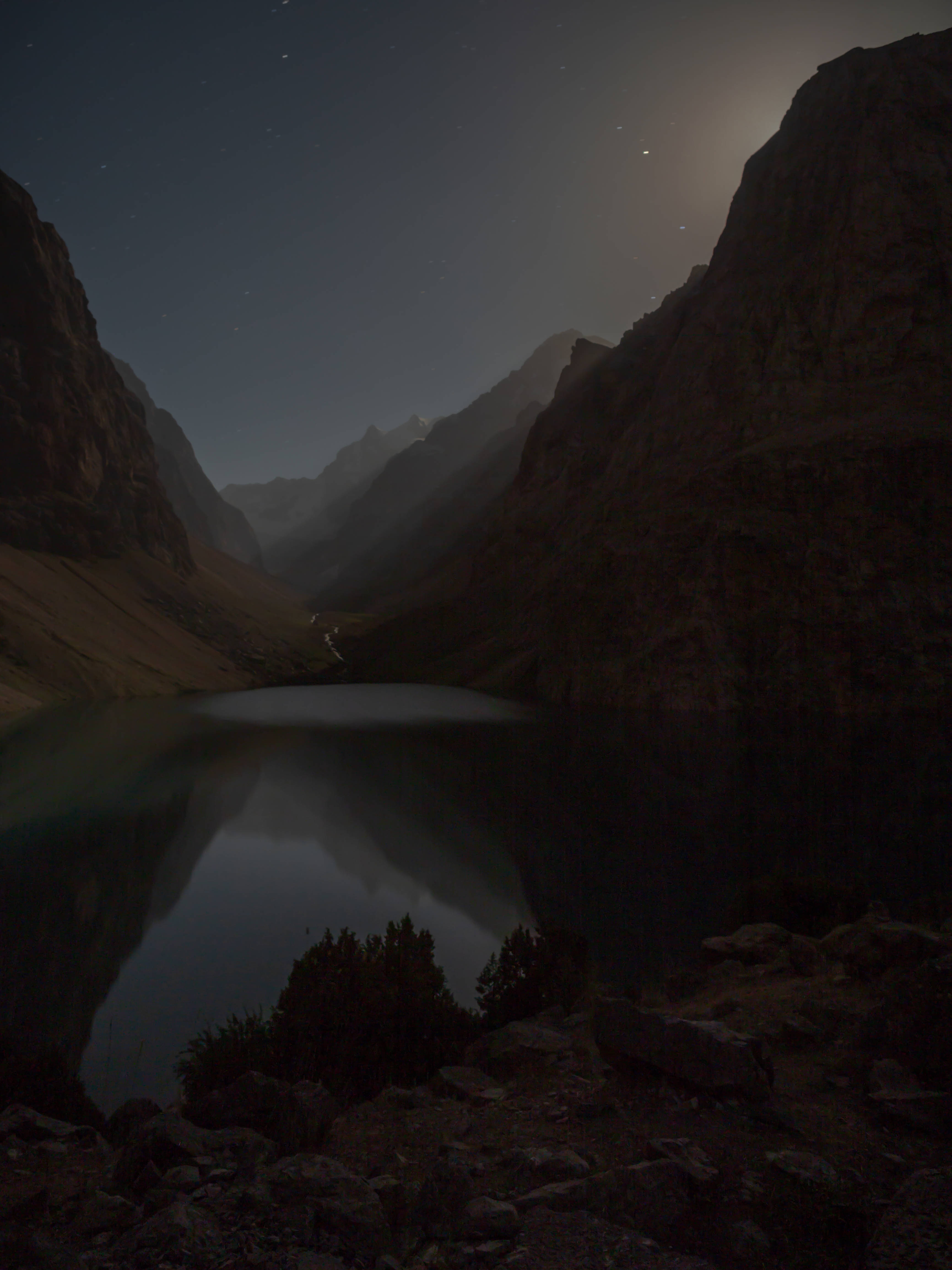 Tajikistan 桌布 壁紙 — 星空夜空倒映在寧靜的山間湖泊中，湖泊坐落於高聳的岩石峭壁之間。