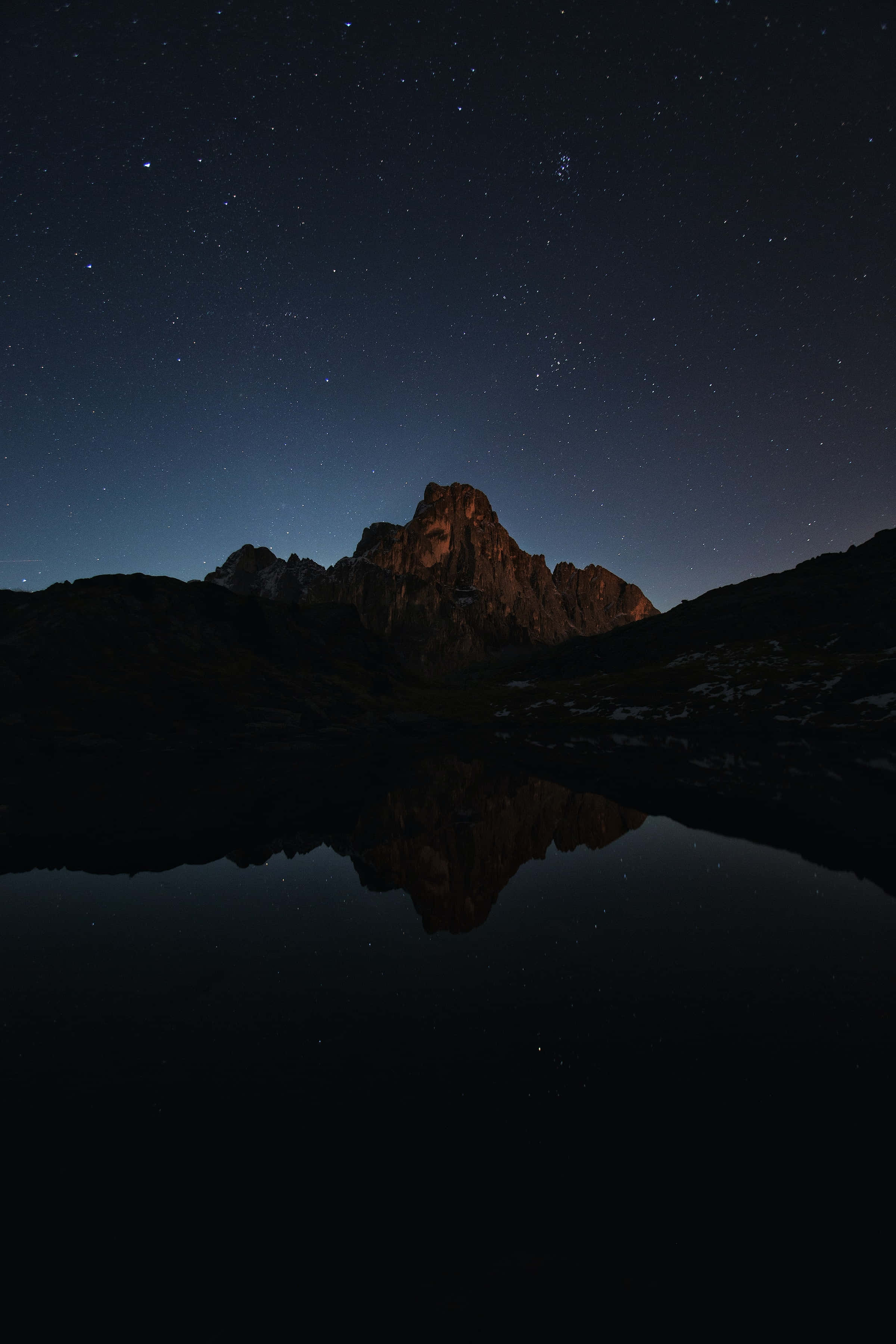 Dark Mountain 桌布 壁紙 — 星空夜空完美倒映在崎嶇山峰下的平靜湖面上。