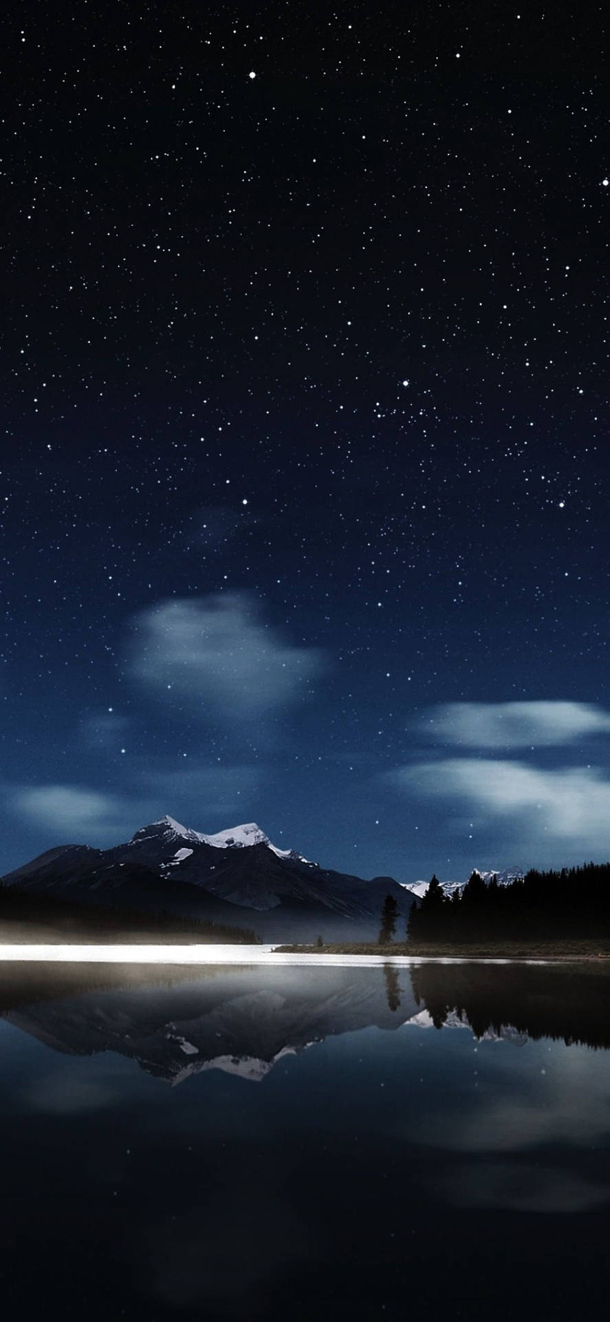 星空夜空倒映在平靜的湖面上，伴有積雪的山峰和樹木。 — 星星動圖 壁紙