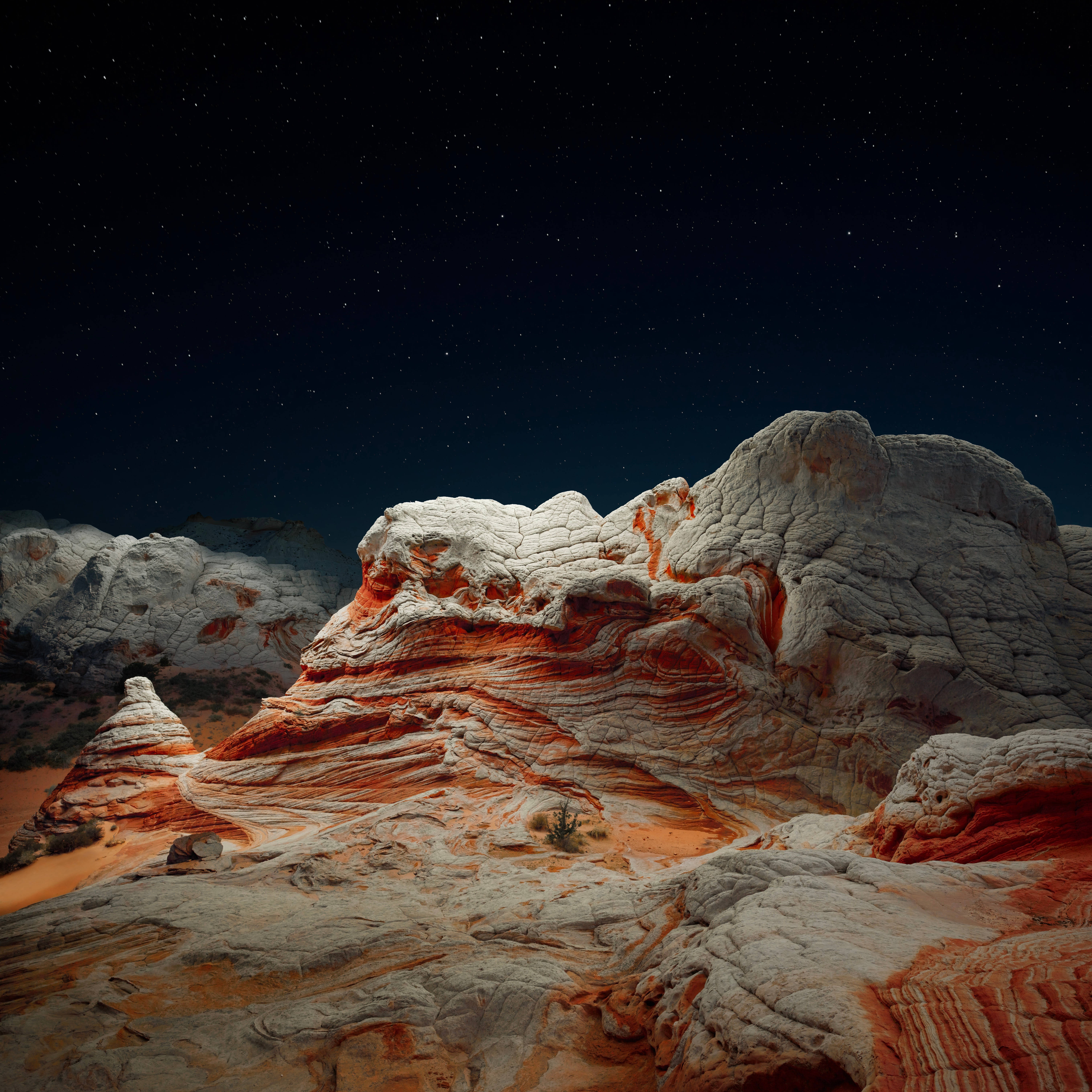 Sur 桌布 壁紙 — 星空夜空拱形覆蓋在層疊的紅色和白色岩層上，表面有紋理，沙漠植被稀疏。