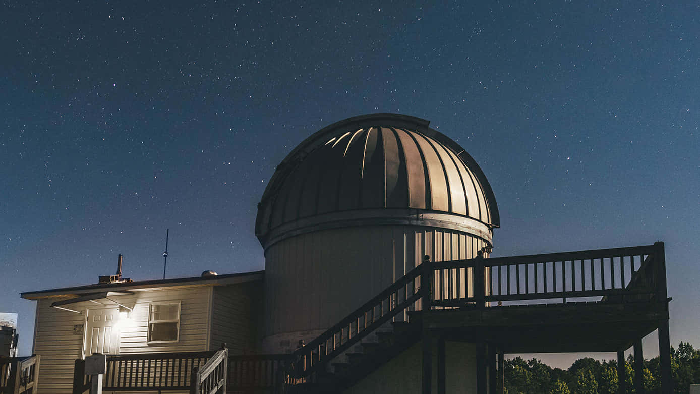Observatory 桌布 壁紙 — 星空夜空照亮了圓頂天文台，溫暖的燈光從窗戶和周圍的甲板散發出來。