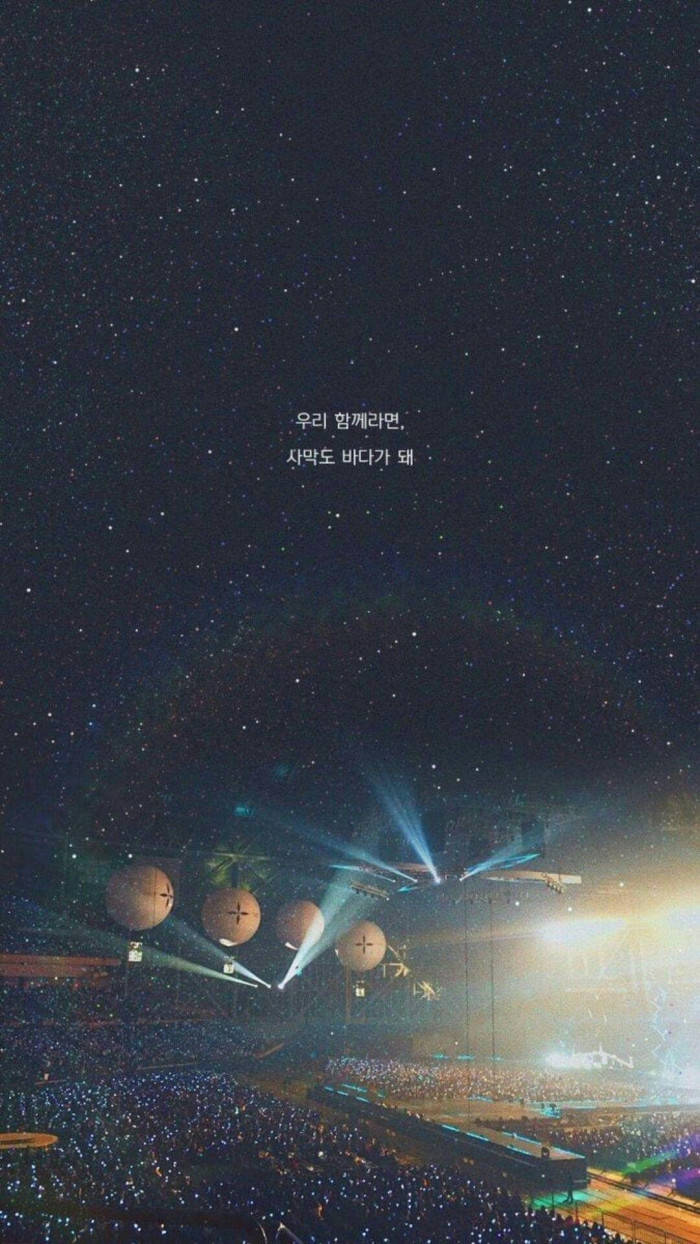 BTS 桌布 壁紙 — 星空籠罩著燈火通明的演唱會舞台，發光的球體和觀眾手機燈光形成一片光海。