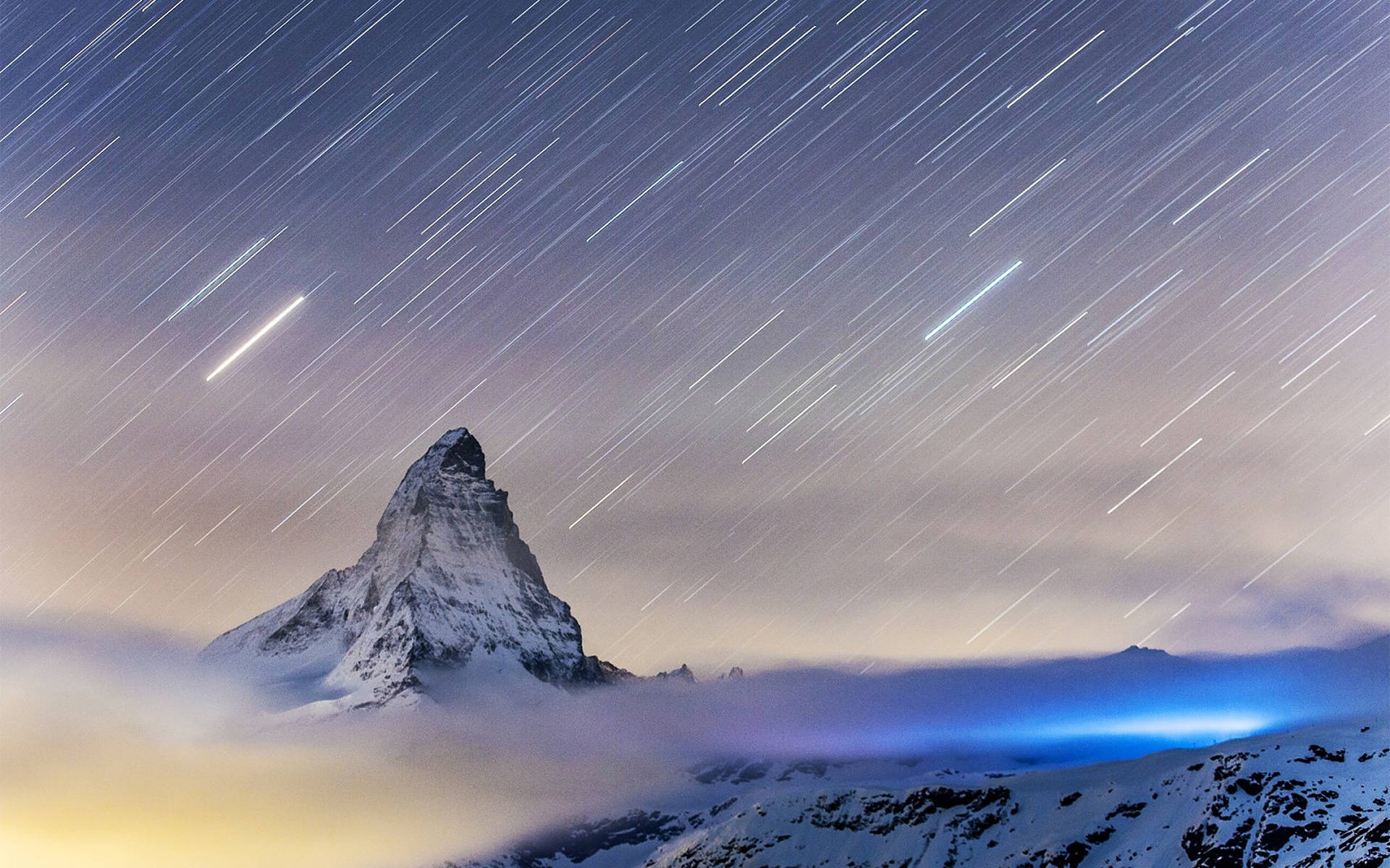 Alps 桌布 壁紙 — 星軌劃過夜空，位於雲層之上、白雪覆蓋的馬特洪峰山頂。