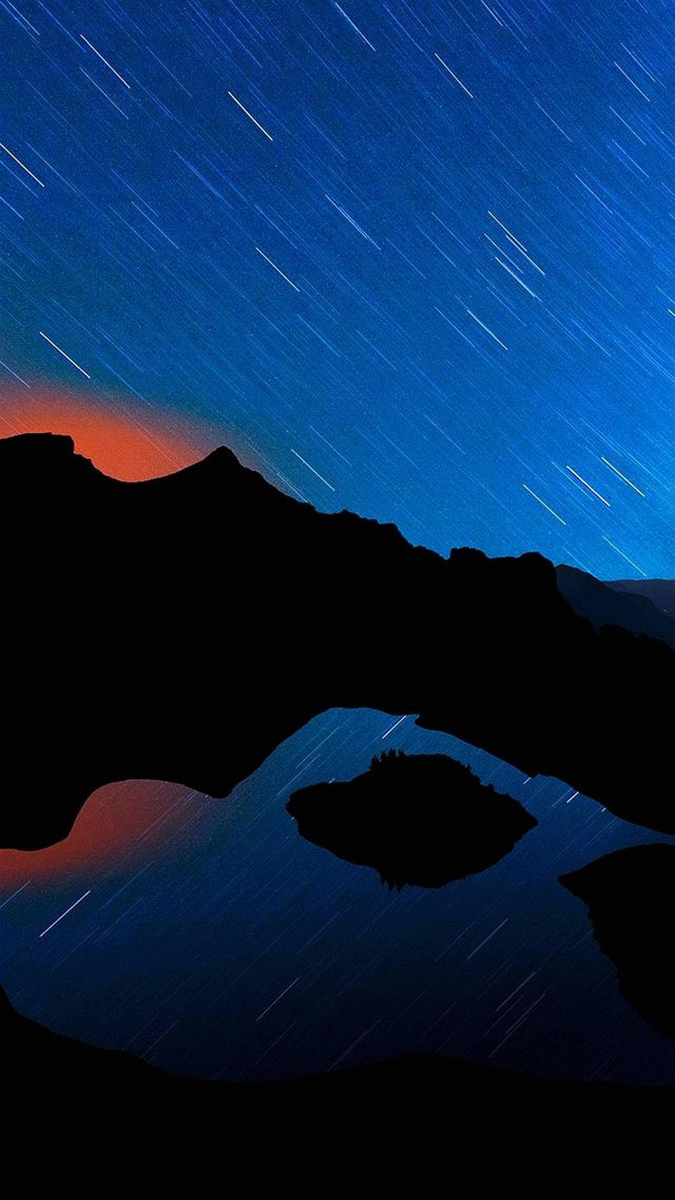 Best Smartphone 桌布 壁紙 — 星軌在深藍色的夜空中劃過，映襯著剪影般的山脈和反射的湖泊。