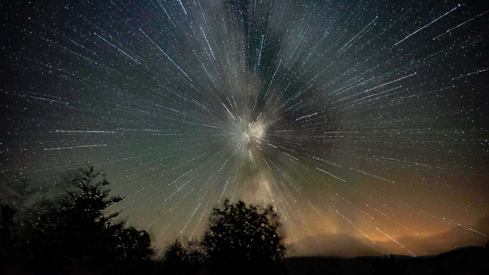 meteor 桌布 壁紙 — 星軌從黑暗夜空中的一個明亮天體點放射而出，上方是剪影般的樹木。