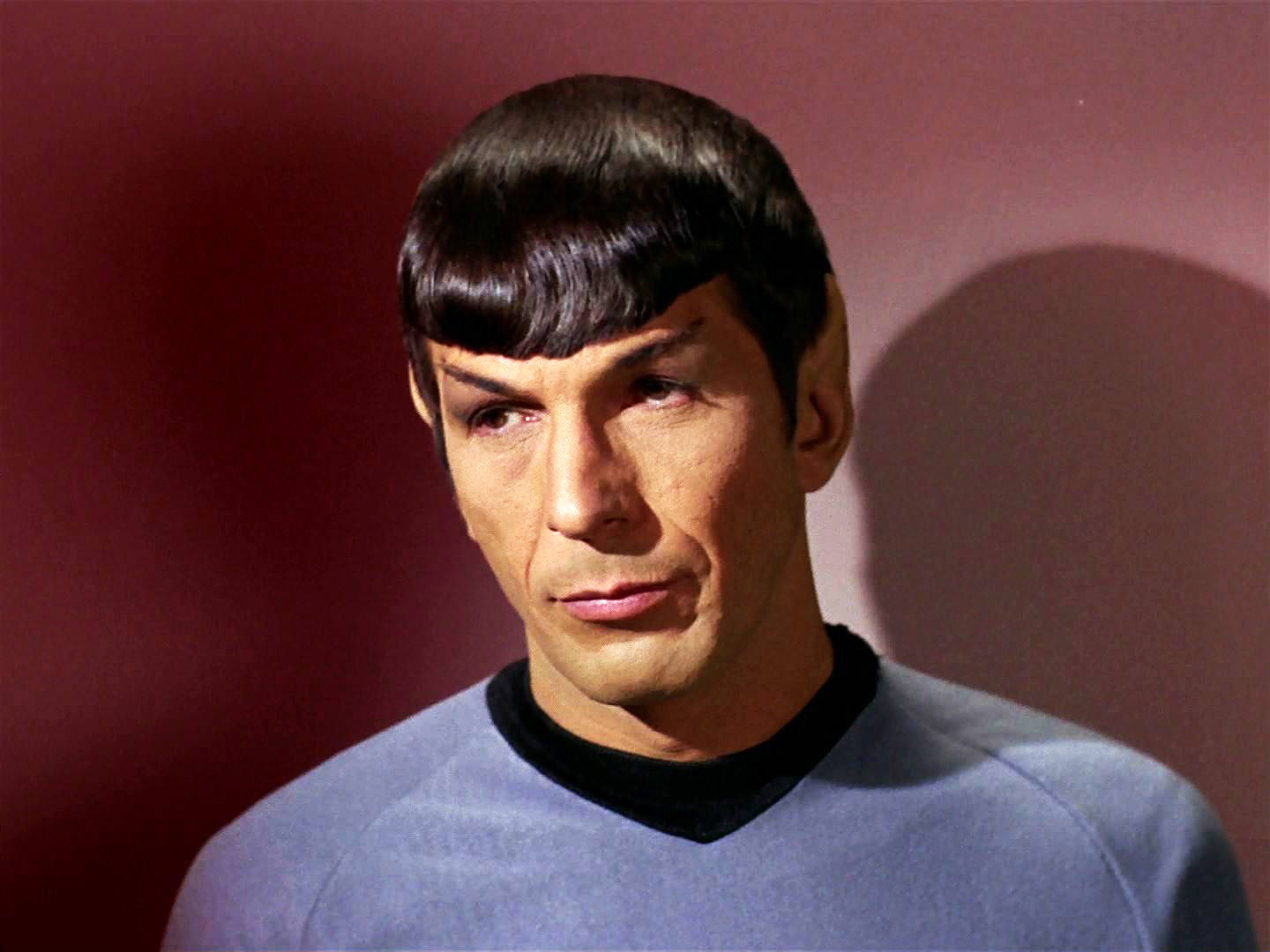 Spock 桌布 壁紙 — 《星際爭霸戰》中史波克的近距離肖像，表情嚴肅，背景為深紅色。