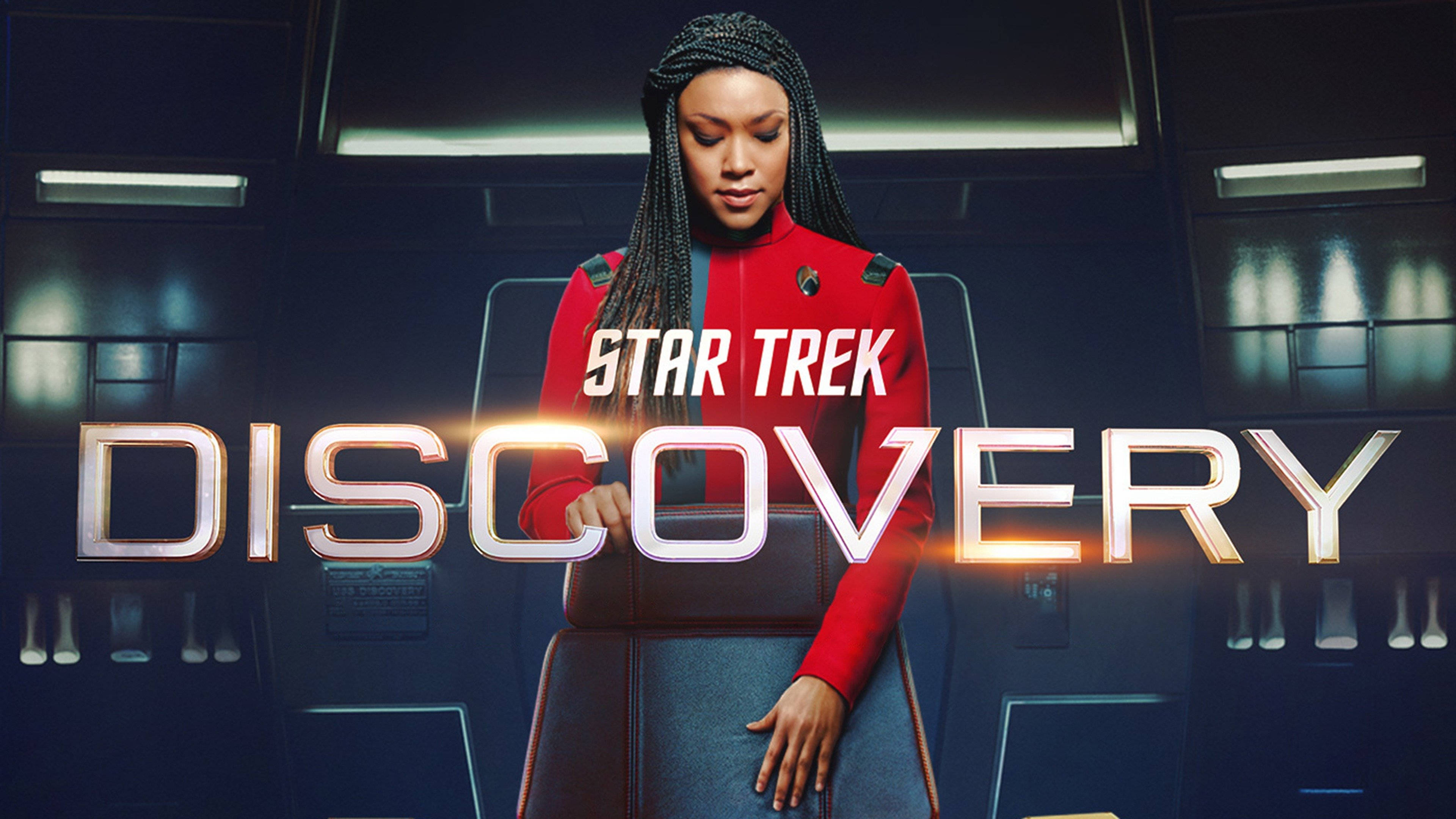 Discovery 桌布 壁紙 — 星際爭霸戰：發現號的紅色制服船員站在未來主義的太空船艦橋上，帶有發光的金屬標題文字。