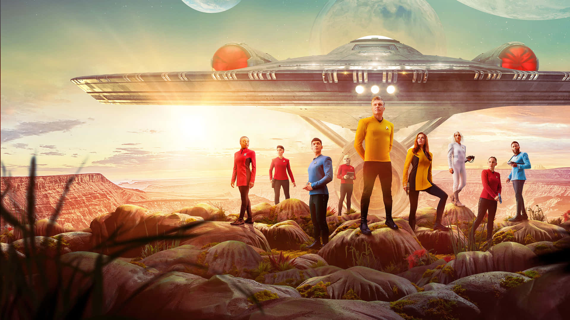 Starship 桌布 壁紙 — 《星際爭霸戰》船員站在外星岩石地形上，飛船在他們上方，夕陽在巨大月球後方發光。