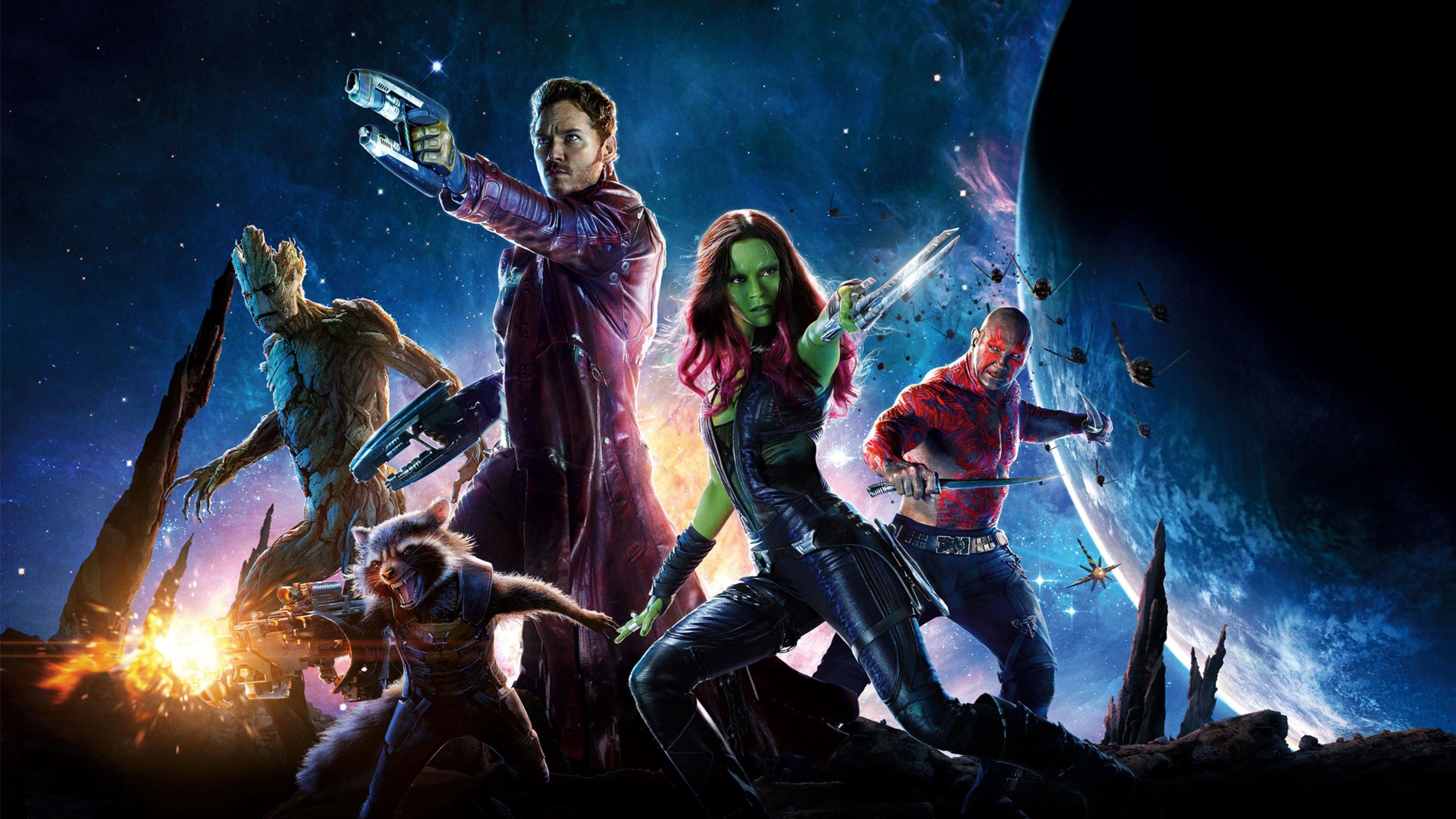 Guardians Of The Galaxy 2 桌布 壁紙 — 星際異攻隊英雄式地站在一個岩石外星行星上，背景是星空和一顆巨大行星。