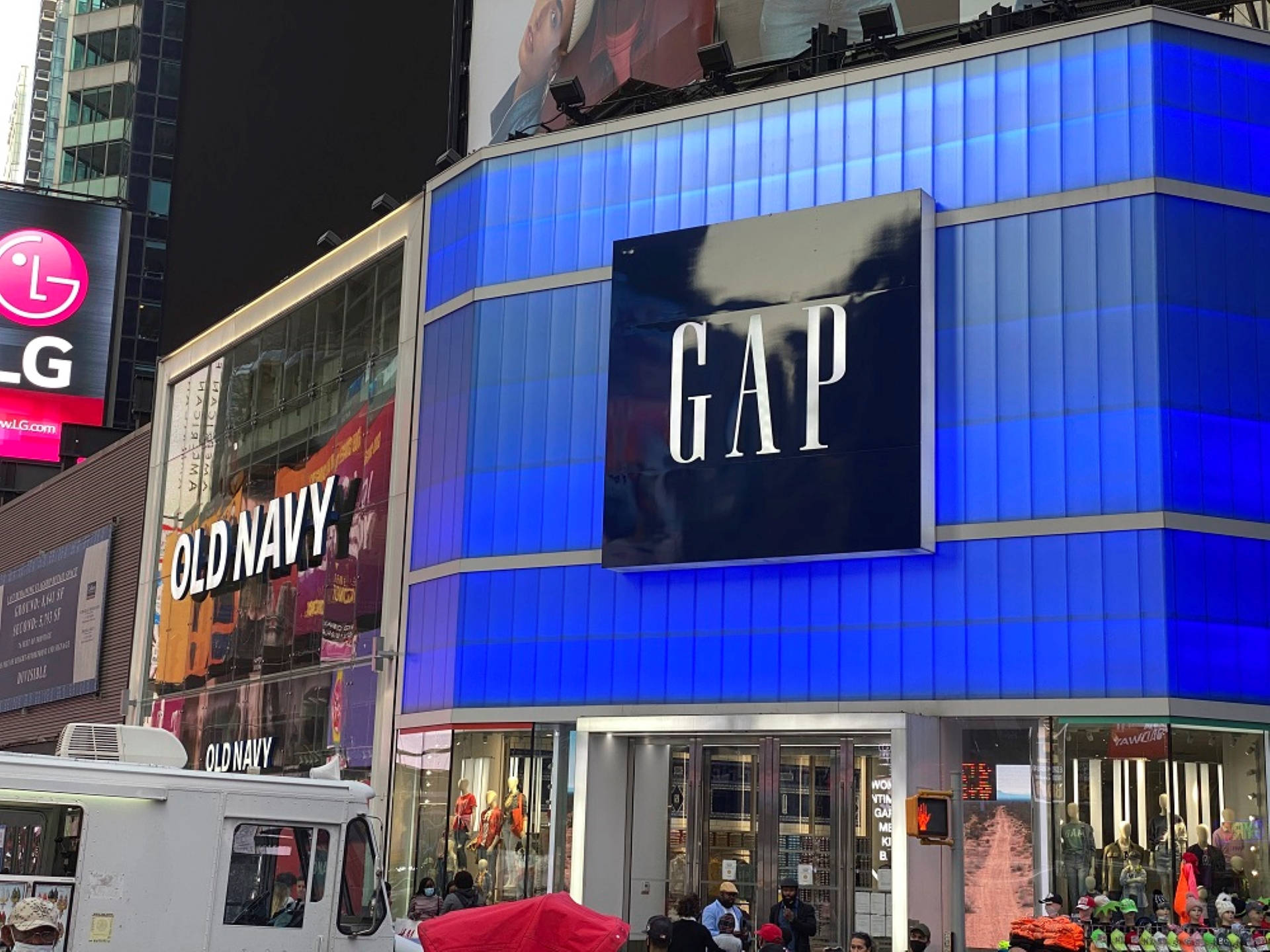 Gap 桌布 壁紙 — 時代廣場充滿活力的夜景，特色是發光的藍色GAP商店，以及相鄰的Old Navy和LG廣告看板。
