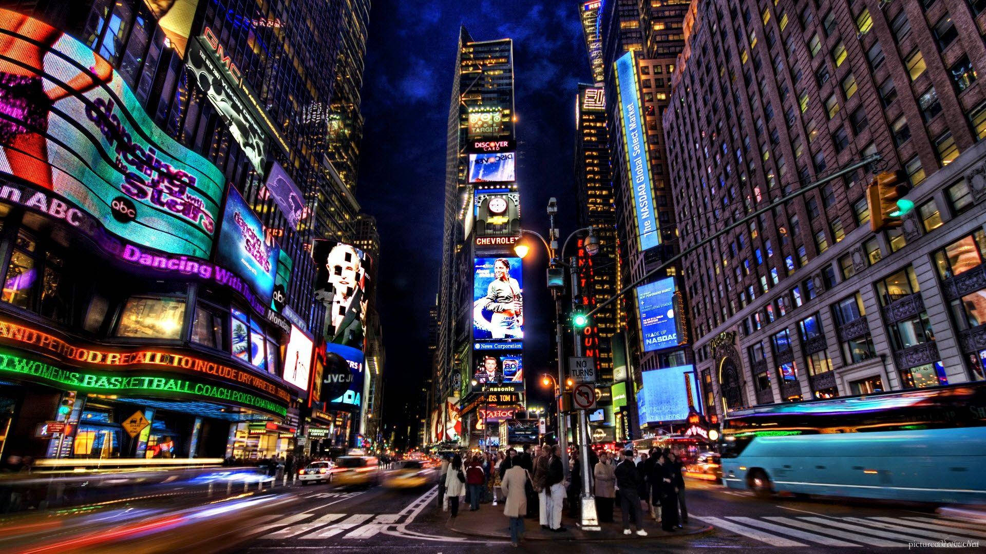 New York 桌布 壁紙 — 時代廣場充滿活力的夜景，閃爍的廣告牌和流動的交通燈光。