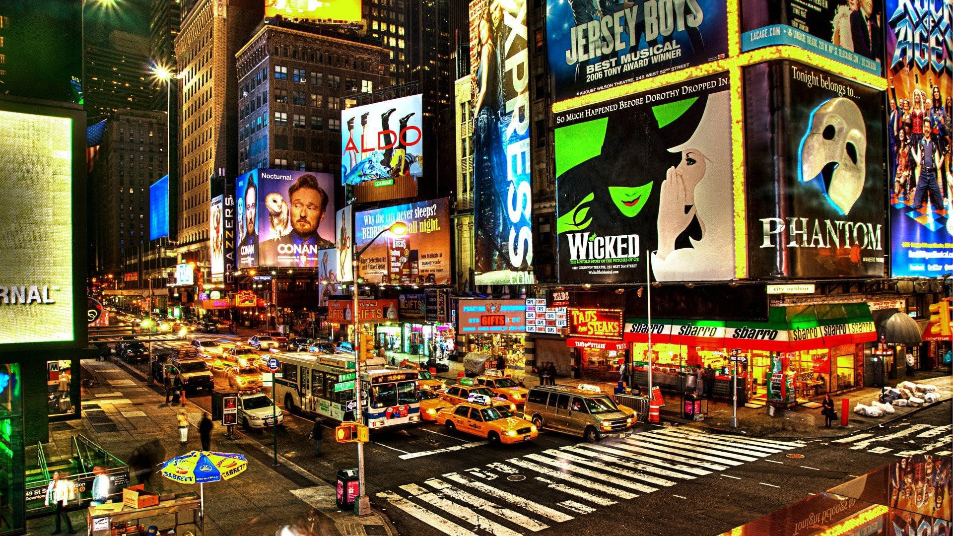 New York 桌布 壁紙 — 時代廣場充滿活力的夜景，閃爍的廣告牌、計程車和繁忙的街道。
