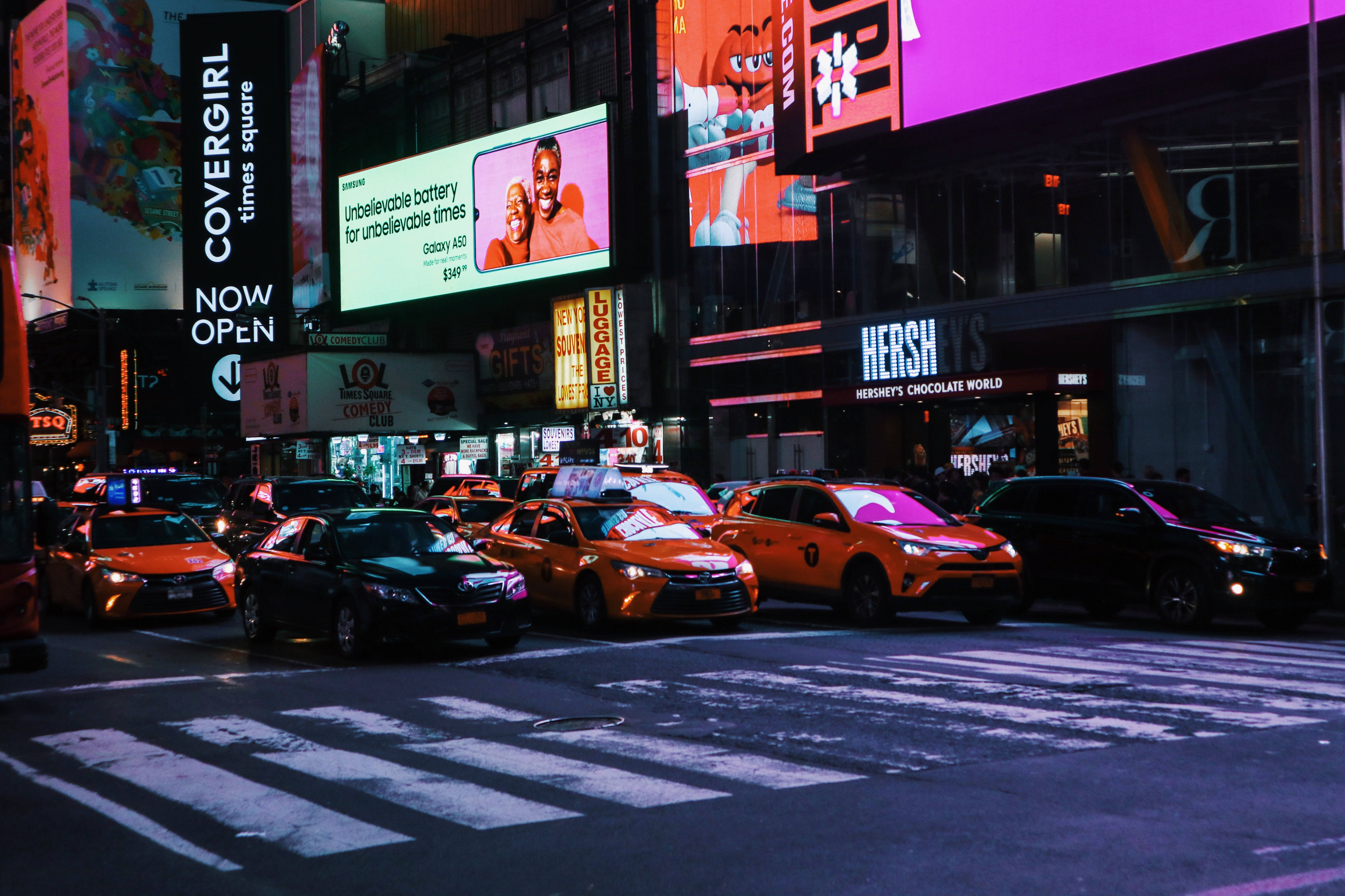Nyc Aesthetic 桌布 壁紙 — 時代廣場充滿活力的夜間街景，閃爍的廣告牌和橙色計程車正在過馬路。
