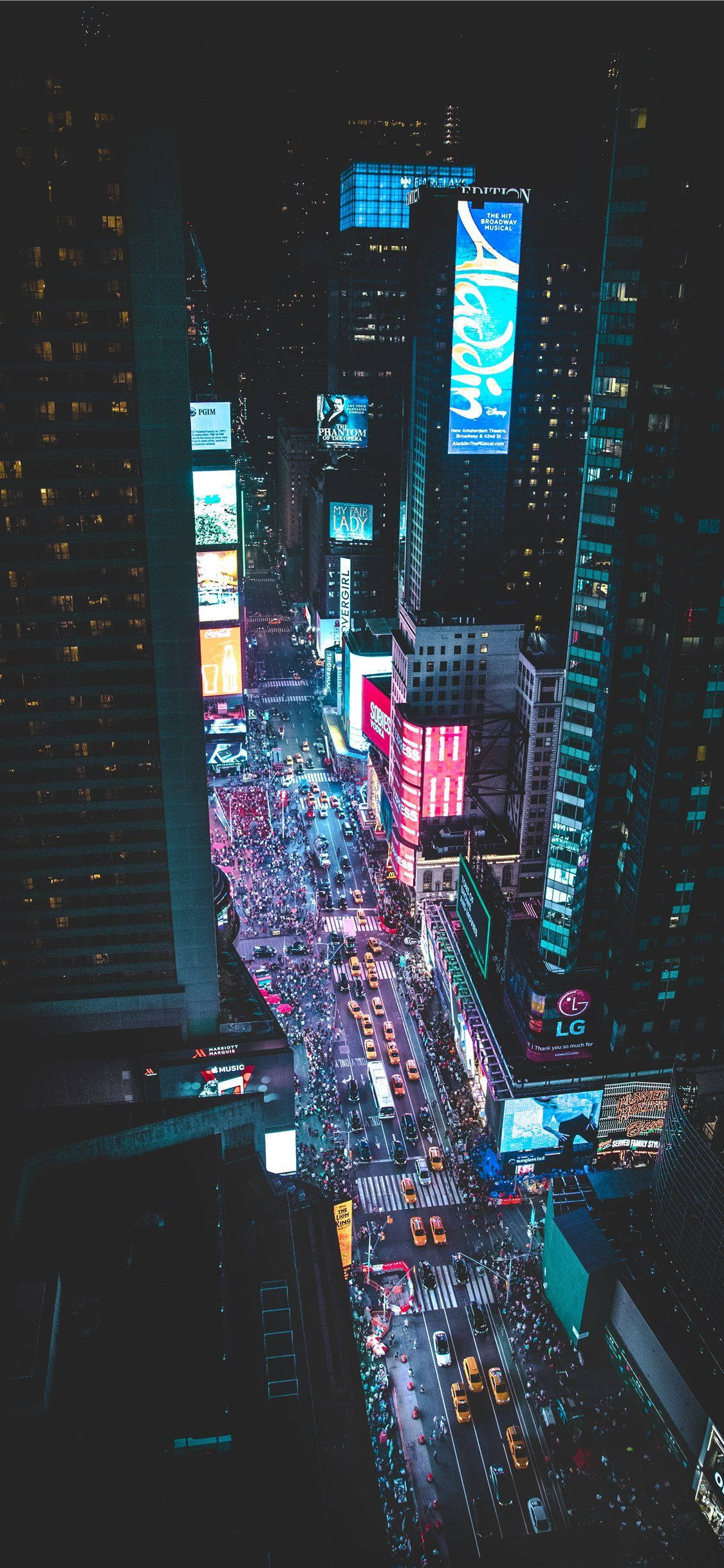城市 桌布 壁紙 — 時代廣場的夜間空中景觀，下方有發光的廣告牌和擁擠的街道。