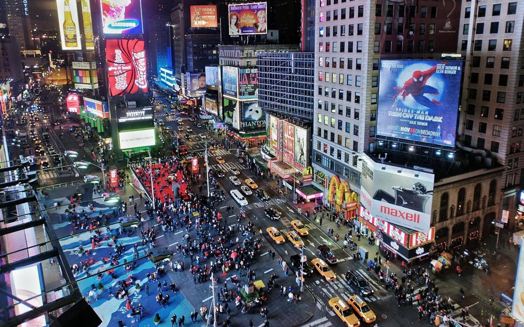 Broadway 桌布 壁紙 — 時代廣場的夜間空中景觀，擠滿人群、發光的廣告牌和黃色的士，在城市的燈光下。