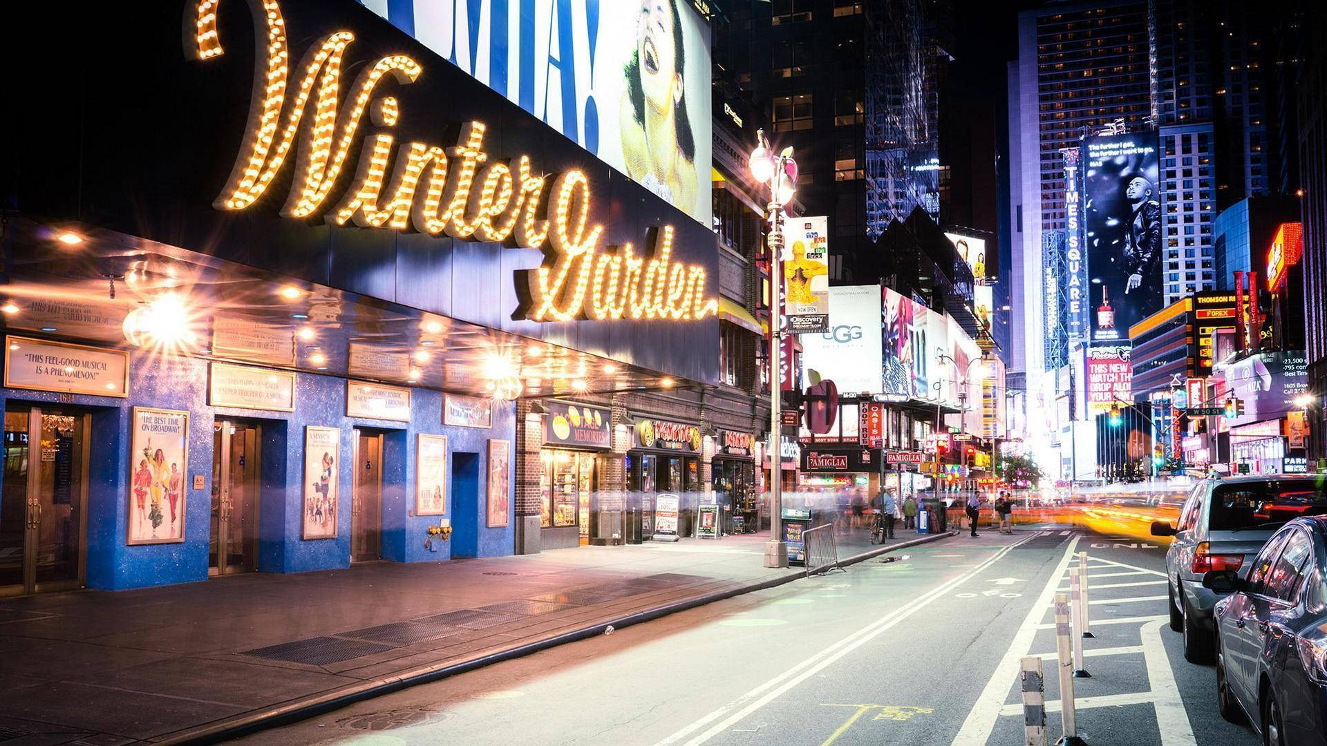 Broadway 桌布 壁紙 — 時代廣場的迷人夜景，閃爍的廣告牌和流動的車燈照亮了繁華的城市街道。
