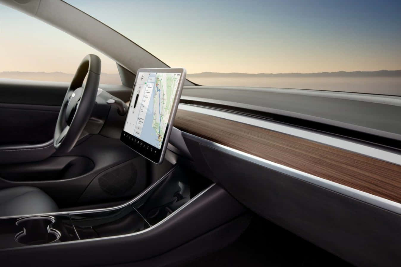 Tesla Model 3 桌布 壁紙 — 時尚 Tesla 車廂內部，配備大型觸控螢幕，在朦朧沙漠日落背景下顯示地圖。