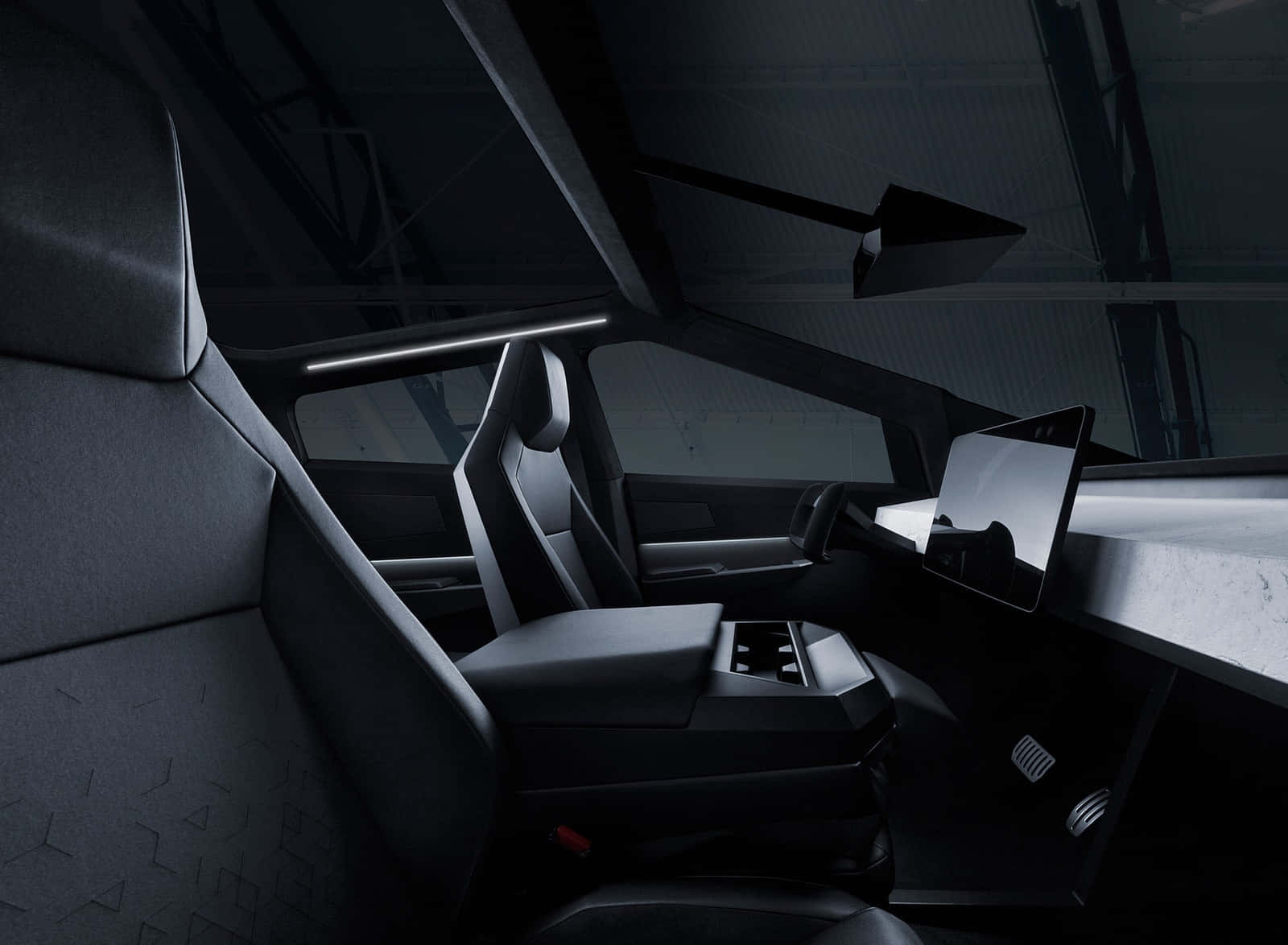 Tesla Cybertruck 桌布 壁紙 — 時尚未來感汽車內部，配備棱角分明的黑色座椅和極簡數位儀表板，在昏暗的環境燈光下。