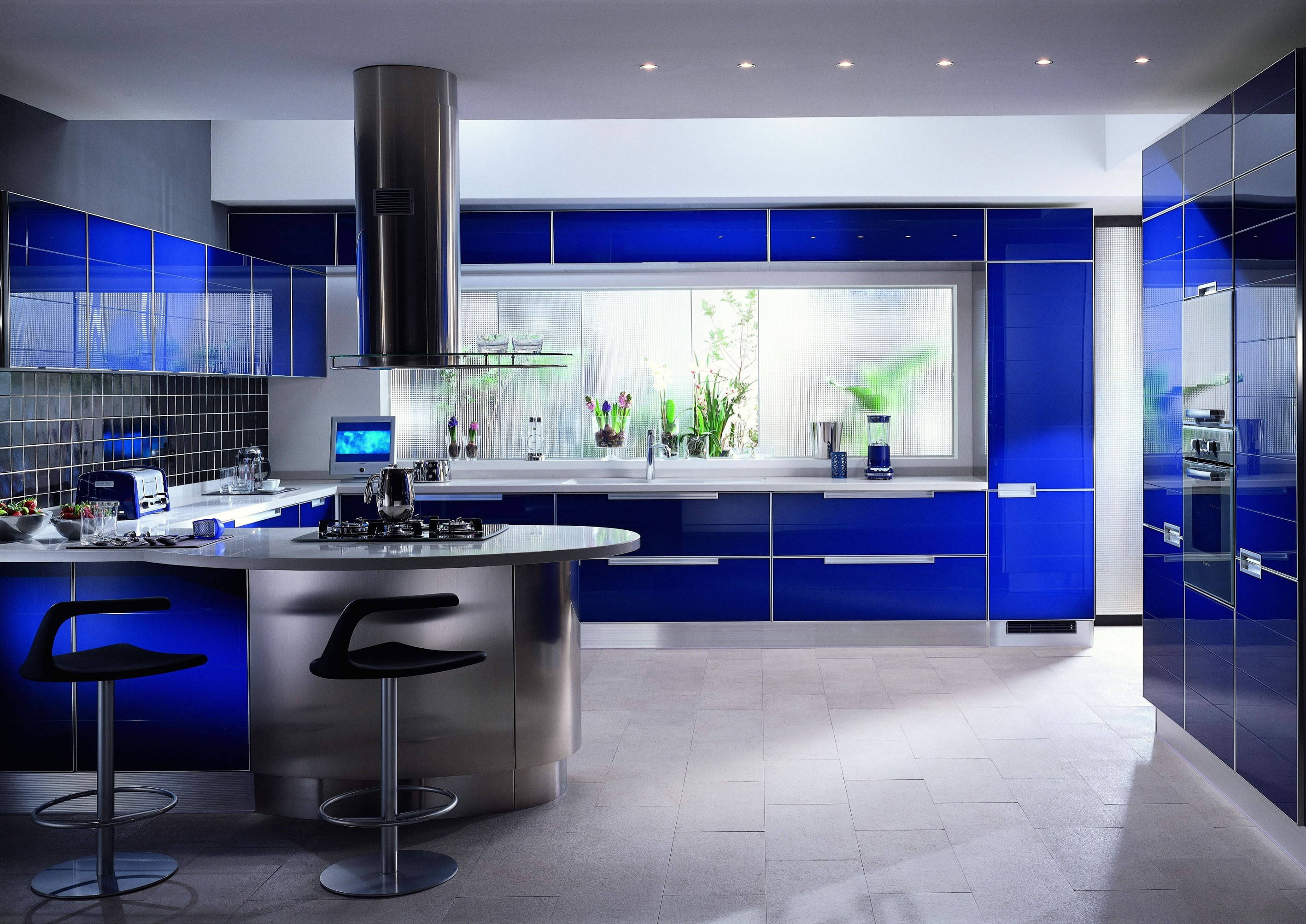 Kitchen Design 桌布 壁紙 — 時尚現代廚房，配有光澤的鈷藍色櫥櫃、不鏽鋼中島和黑色吧檯椅，下方是明亮的嵌入式照明。