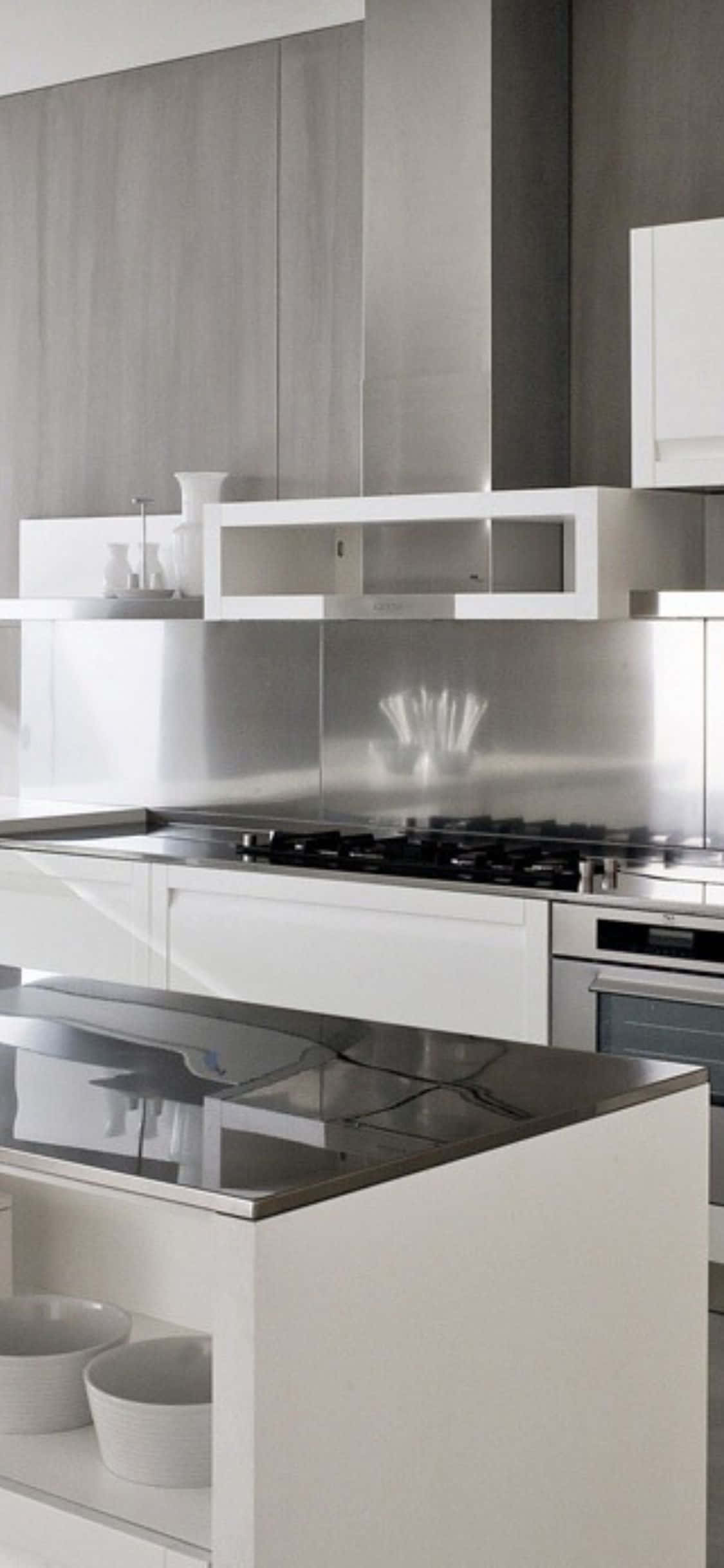 Kitchen 桌布 壁紙 — 時尚現代廚房，配有白色櫥櫃、不鏽鋼電器和明亮燈光下的反光檯面。