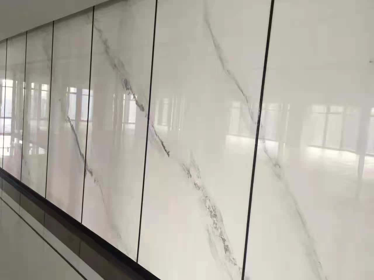 Best Marble 桌布 壁紙 — 時尚現代走廊採用亮面白色大理石面板，帶有灰色紋理和黑色垂直接縫，反射環境光。
