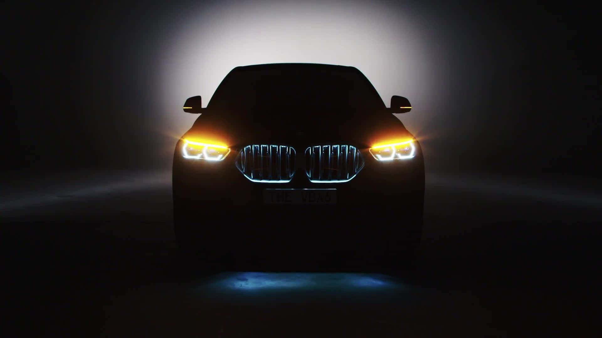 Vantablack 桌布 壁紙 — 時尚的BMW SUV輪廓在黑暗迷濛的背景中閃爍著鮮豔的車頭燈和發光的進氣格柵。