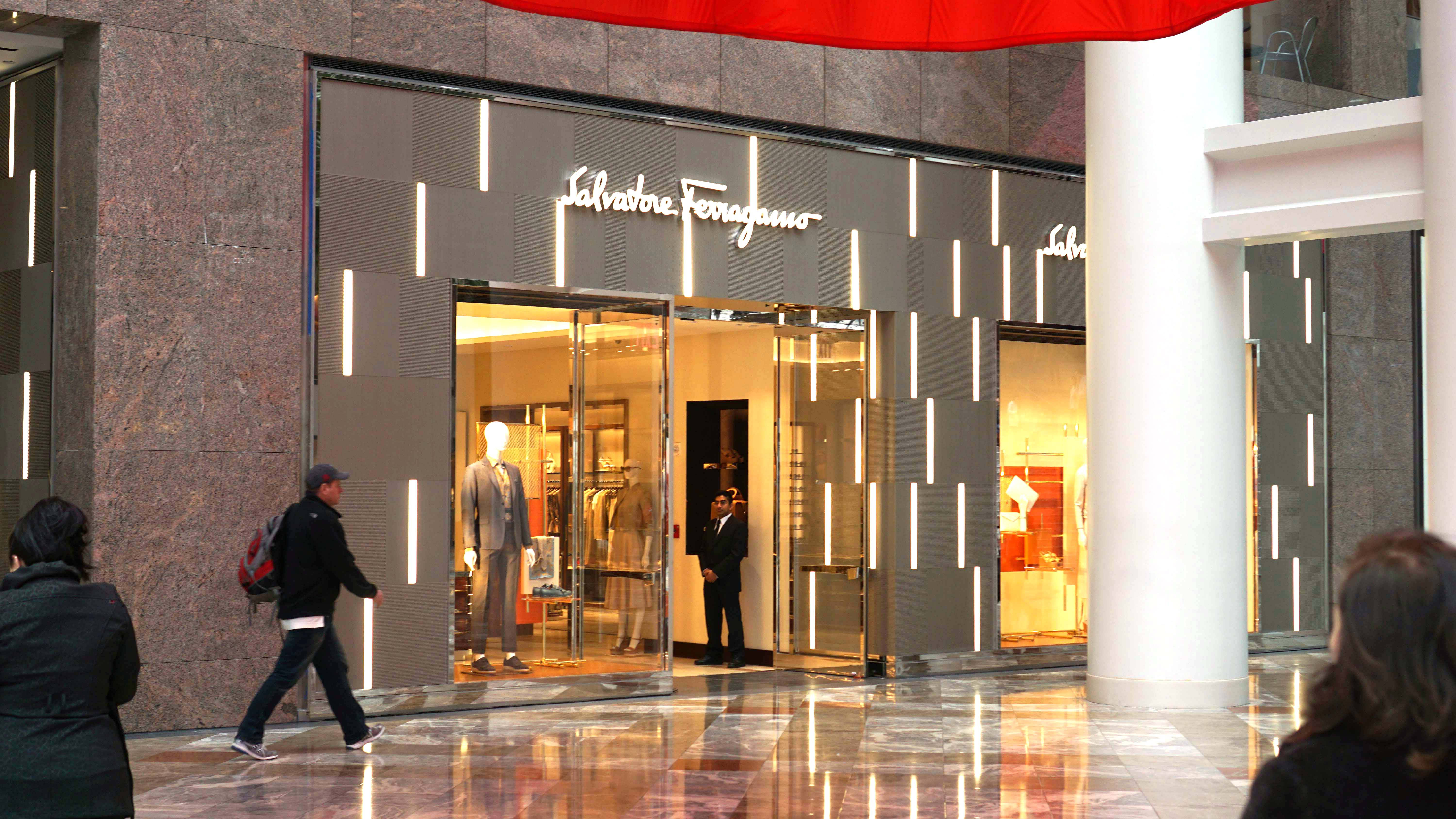 Ferragamo 桌布 壁紙 — 時尚的Salvatore Ferragamo商店，帶有發光的垂直燈光和模特兒，位於拋光的購物中心內部。