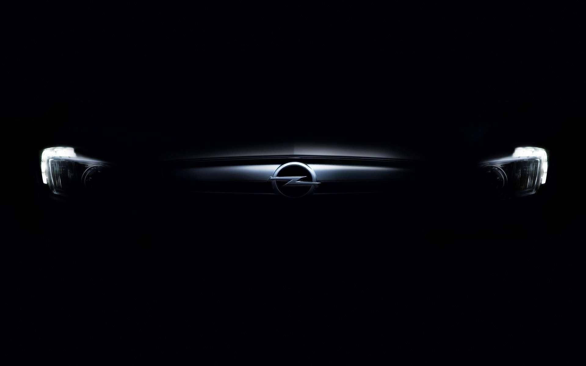 Opel 桌布 壁紙 — 時尚的歐寶汽車前格柵和頭燈在漆黑的背景下微微發光。