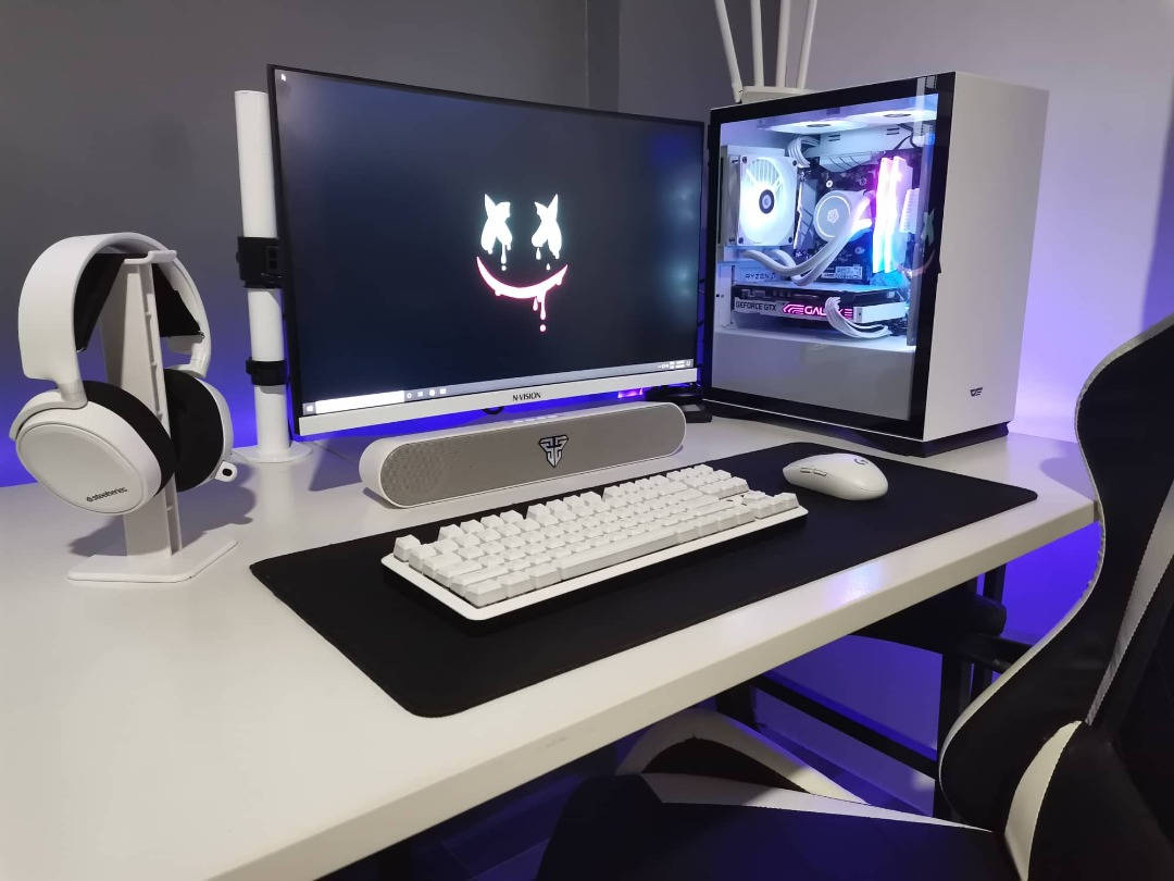 White Pc 桌布 壁紙 — 時尚的白色遊戲設置，配有發光的PC機箱和顯示笑臉標誌的顯示器。