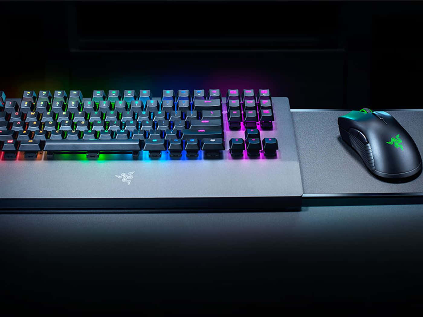 Gaming Mouse 桌布 壁紙 — 時尚的遊戲鍵盤和滑鼠，在深色桌面上散發出鮮豔的彩虹背光。