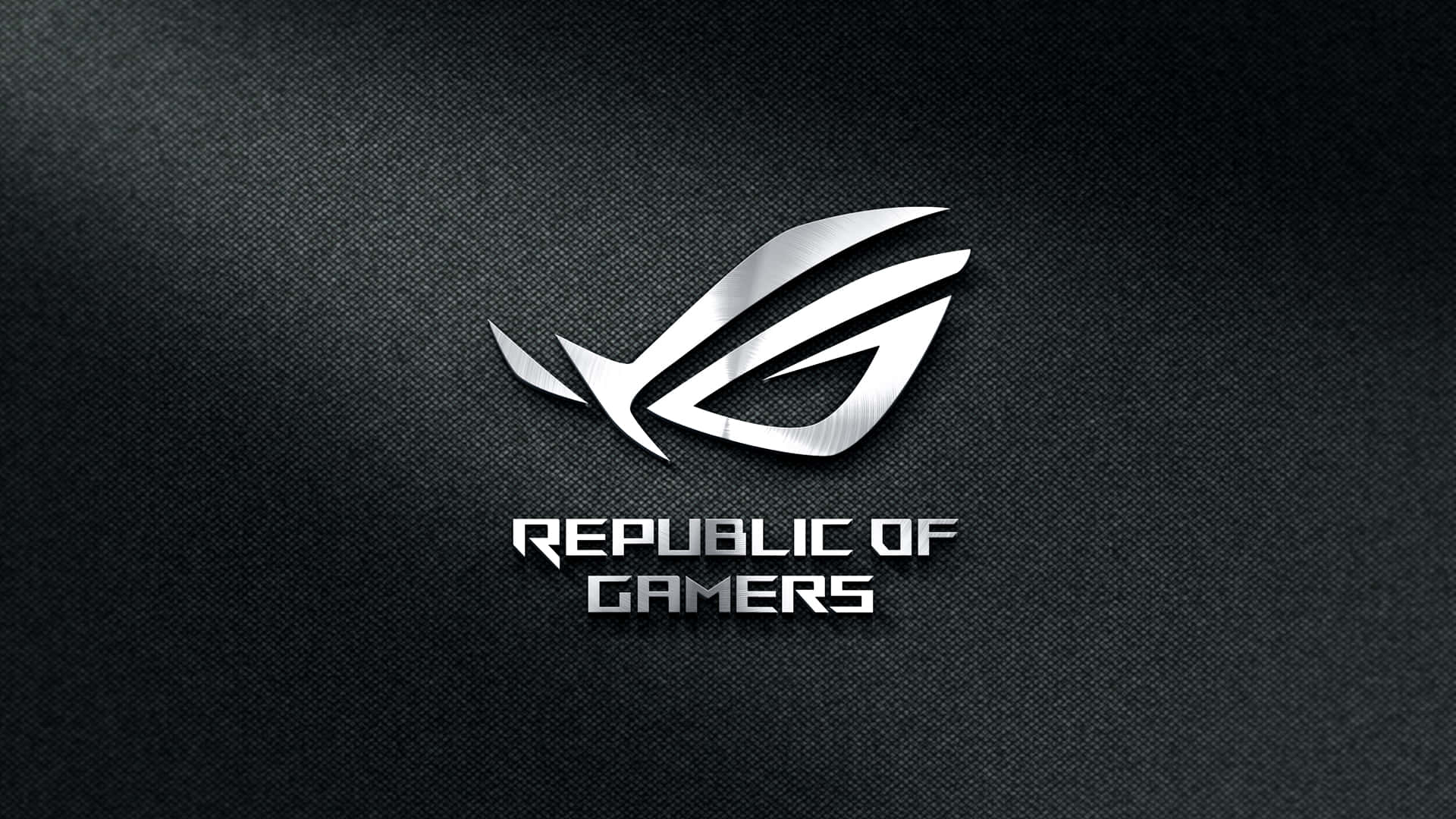 玩家共和國 桌布 壁紙 — 時尚的銀色 ROG 標誌在帶有微妙照明的紋理黑色布料背景上閃耀。