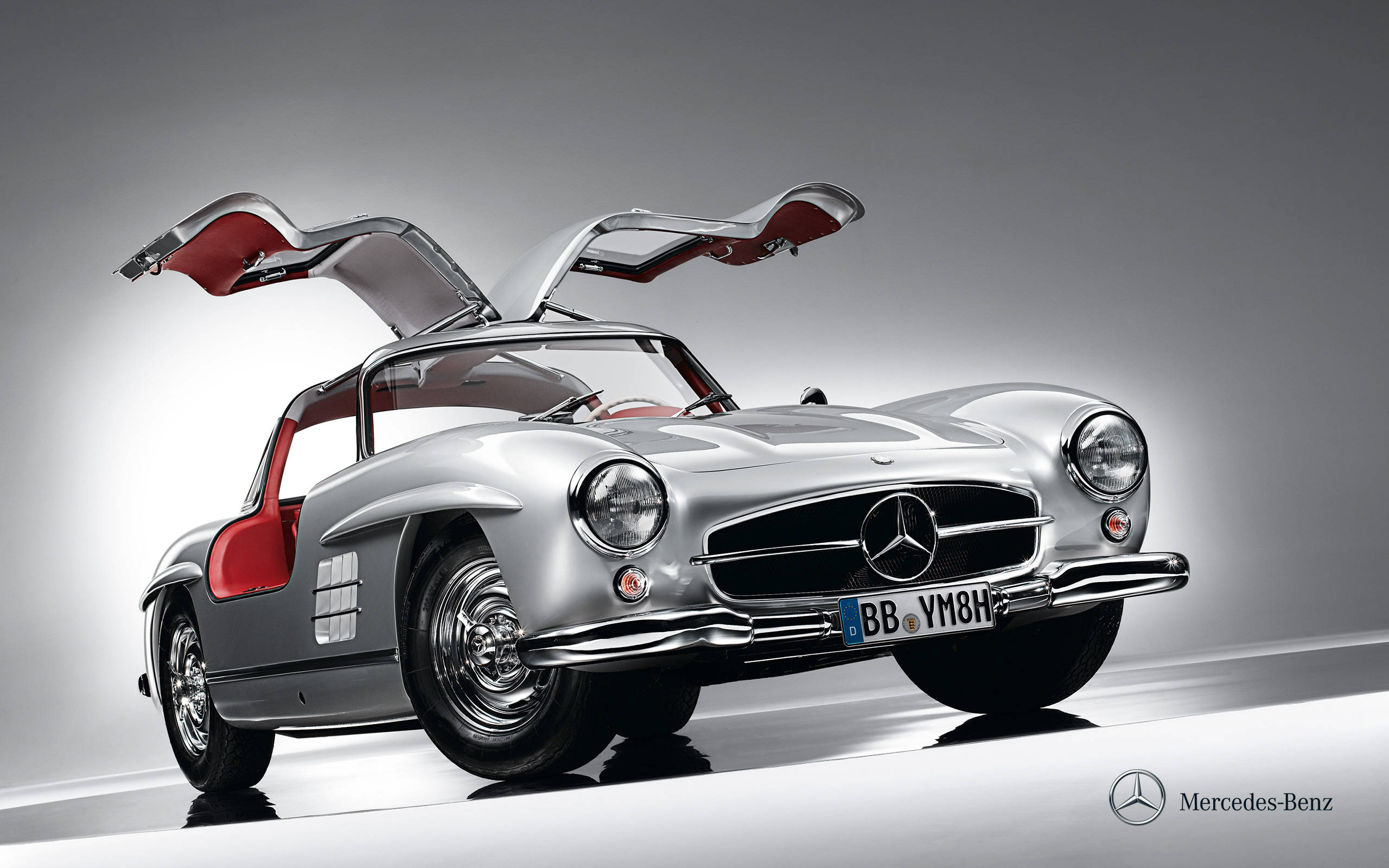 benz 4K 桌布 壁紙 — 時尚的銀色賓士300 SL，鷗翼門打開，在簡約工作室背景下展示紅色內裝。