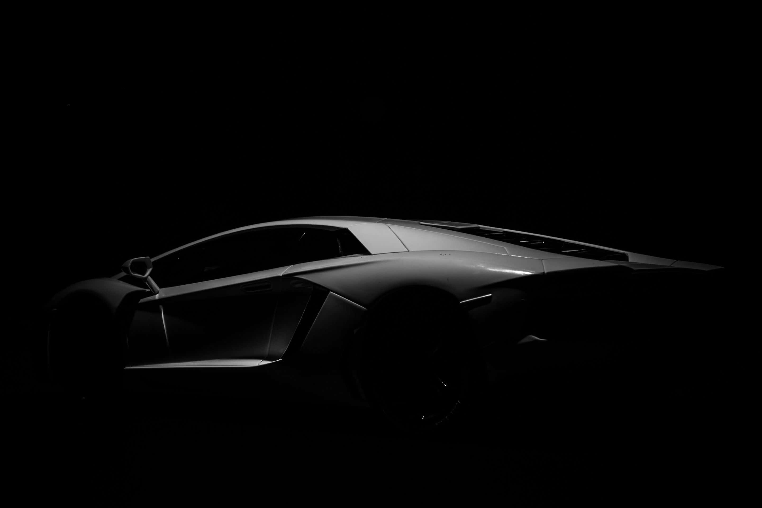 Black And White Car 桌布 壁紙 — 時尚的銀色跑車在漆黑的背景下散發出戲劇性的光芒。