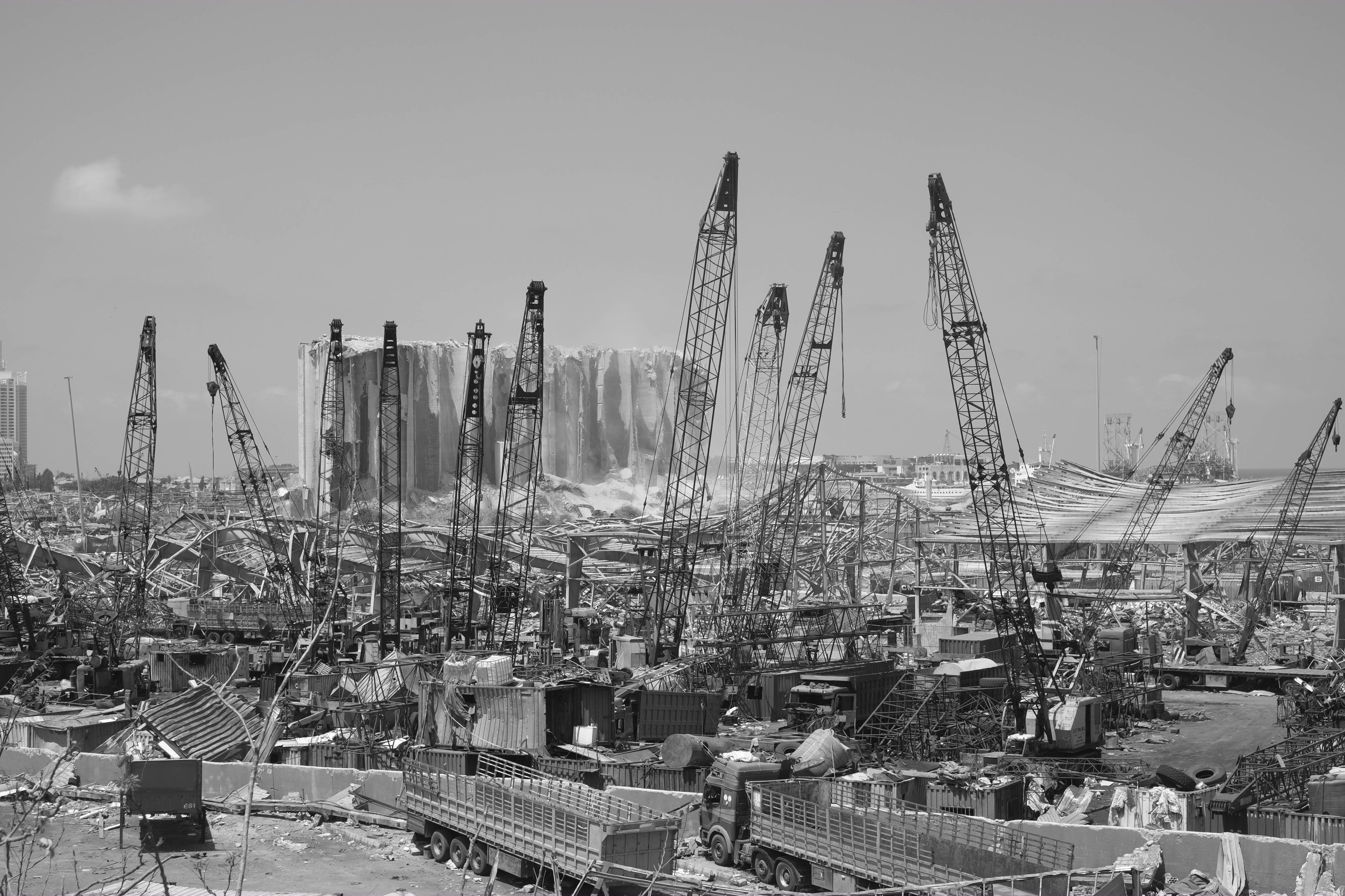 Lebanon 桌布 壁紙 — 晴朗天空下，一個廣闊建築工地充滿高聳起重機和瓦礫的黑白景觀。