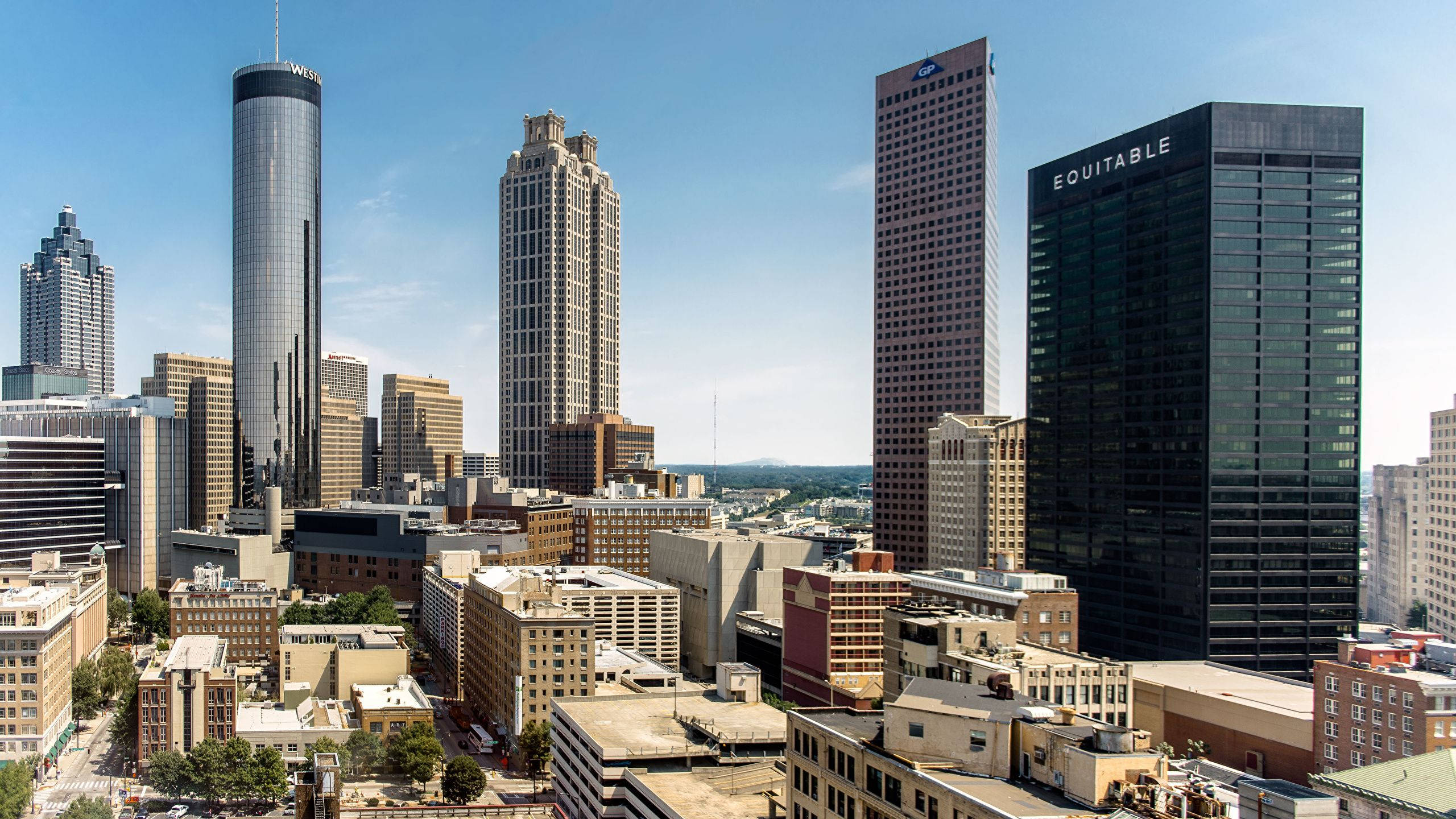 Atlanta 桌布 壁紙 — 晴朗日間鳥瞰密集的城市天際線，高聳的玻璃和鋼鐵摩天大樓在清澈的藍天下。