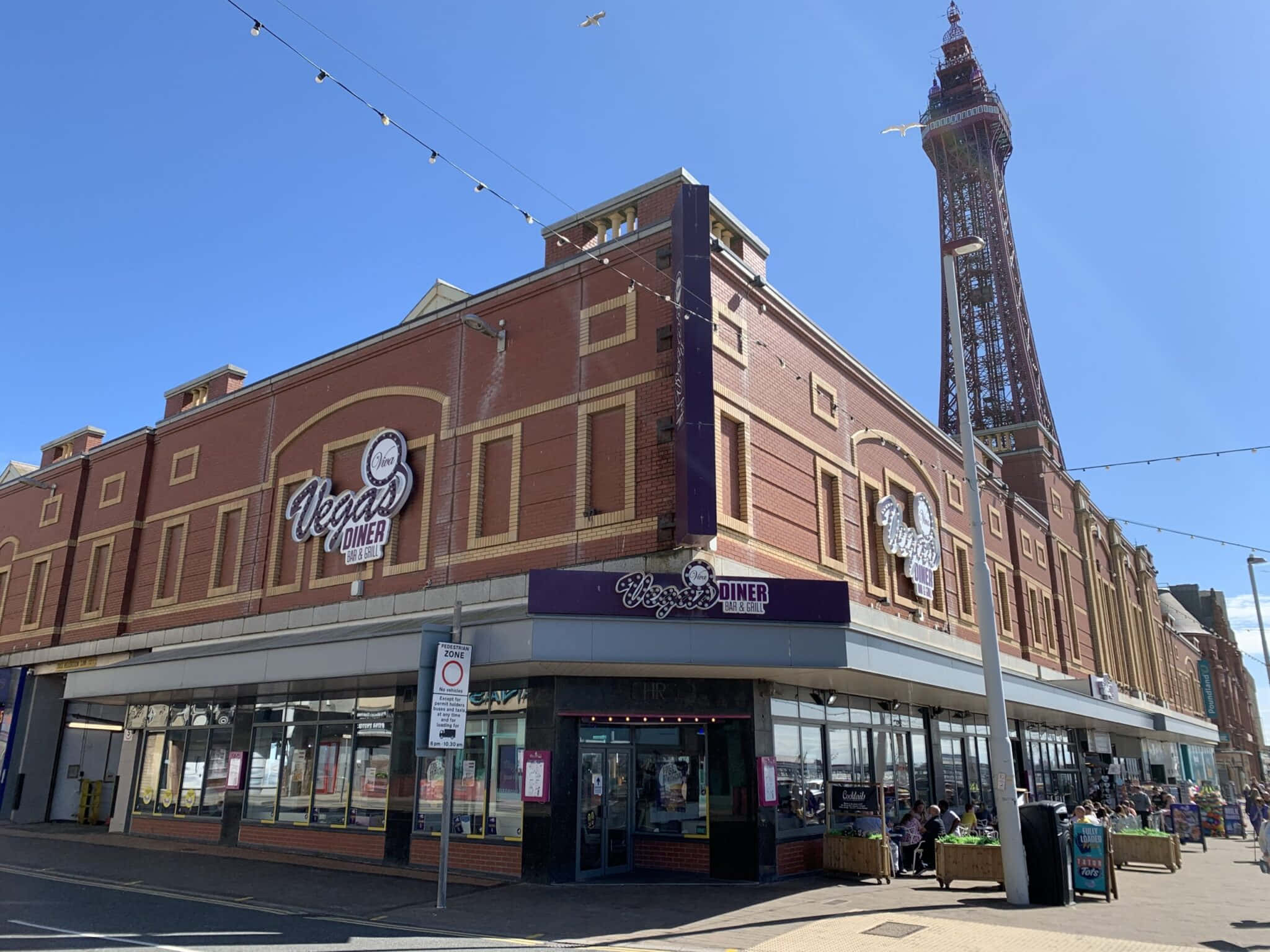 Blue Sky 桌布 壁紙 — 晴朗的日子，在紅磚 Vegas Diner，後面是 Blackpool Tower 在藍天白雲下高聳。