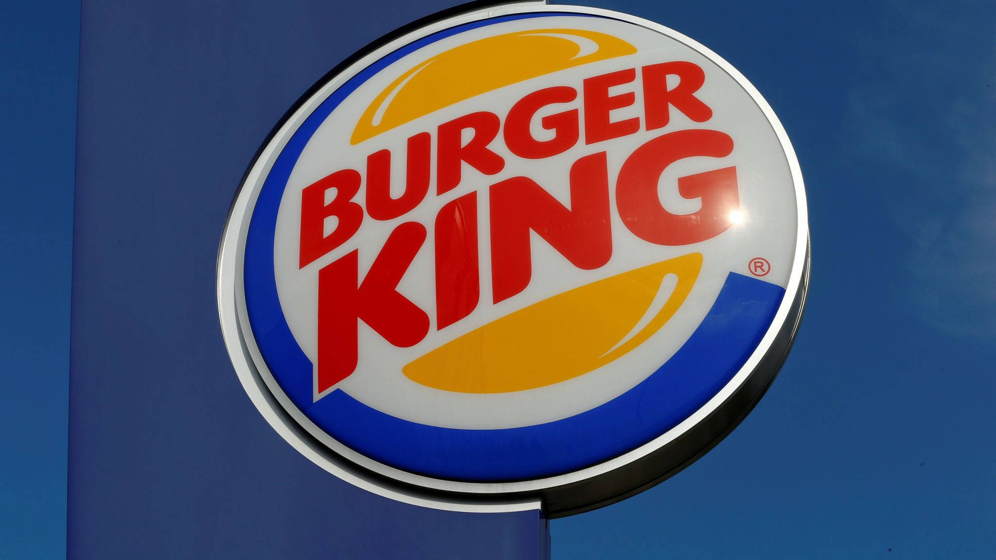 Burger 桌布 壁紙 — 晴朗的日子裡，明亮的漢堡王標誌招牌在清澈的藍天下閃耀。