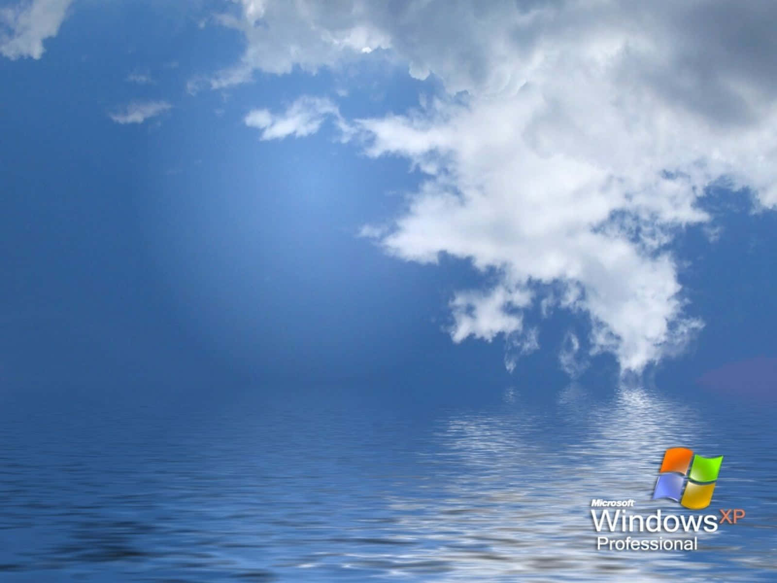 Windows XP 桌布 壁紙 — 晴朗藍天， fluffy 白雲倒映在平靜的海面上，明亮日光下。