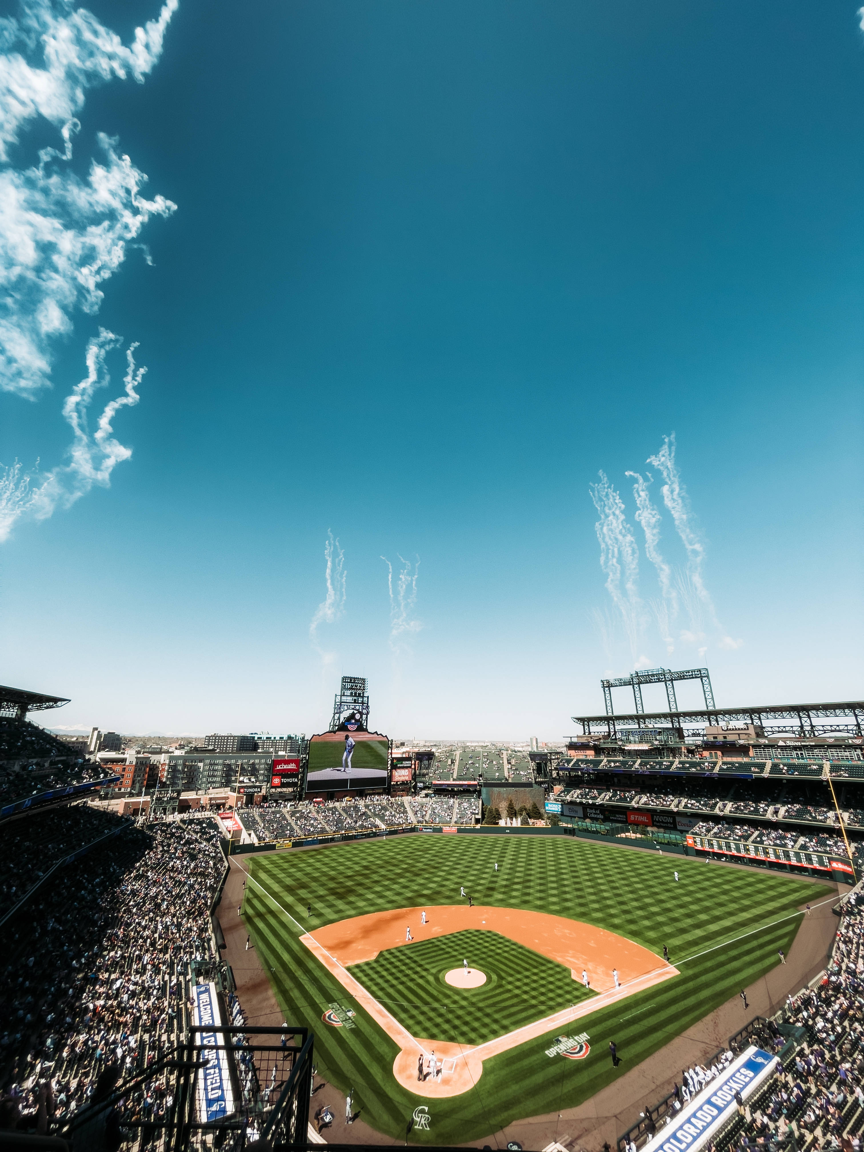 MLB 桌布 壁紙 — 晴朗藍天下，滿座的棒球場上戲劇性的白色煙霧從球場升起，鳥瞰圖。