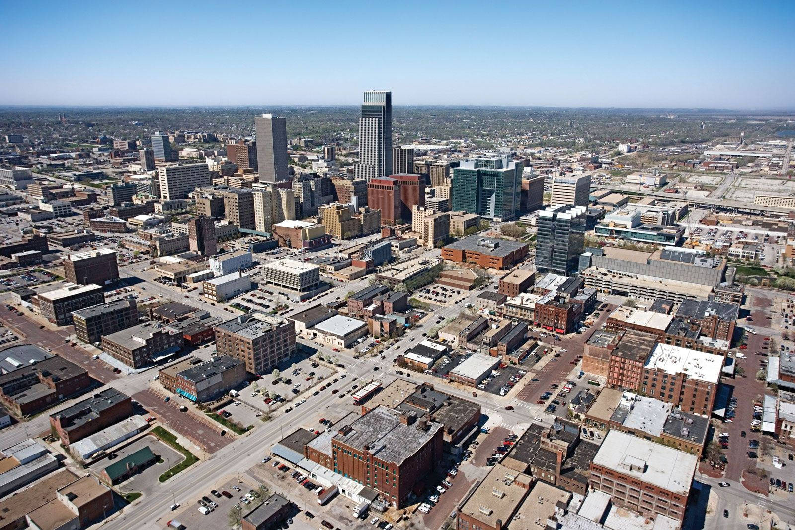 Nebraska 桌布 壁紙 — 晴朗藍天下，現代摩天大樓與低層建築交錯的廣闊城市景觀鳥瞰圖。