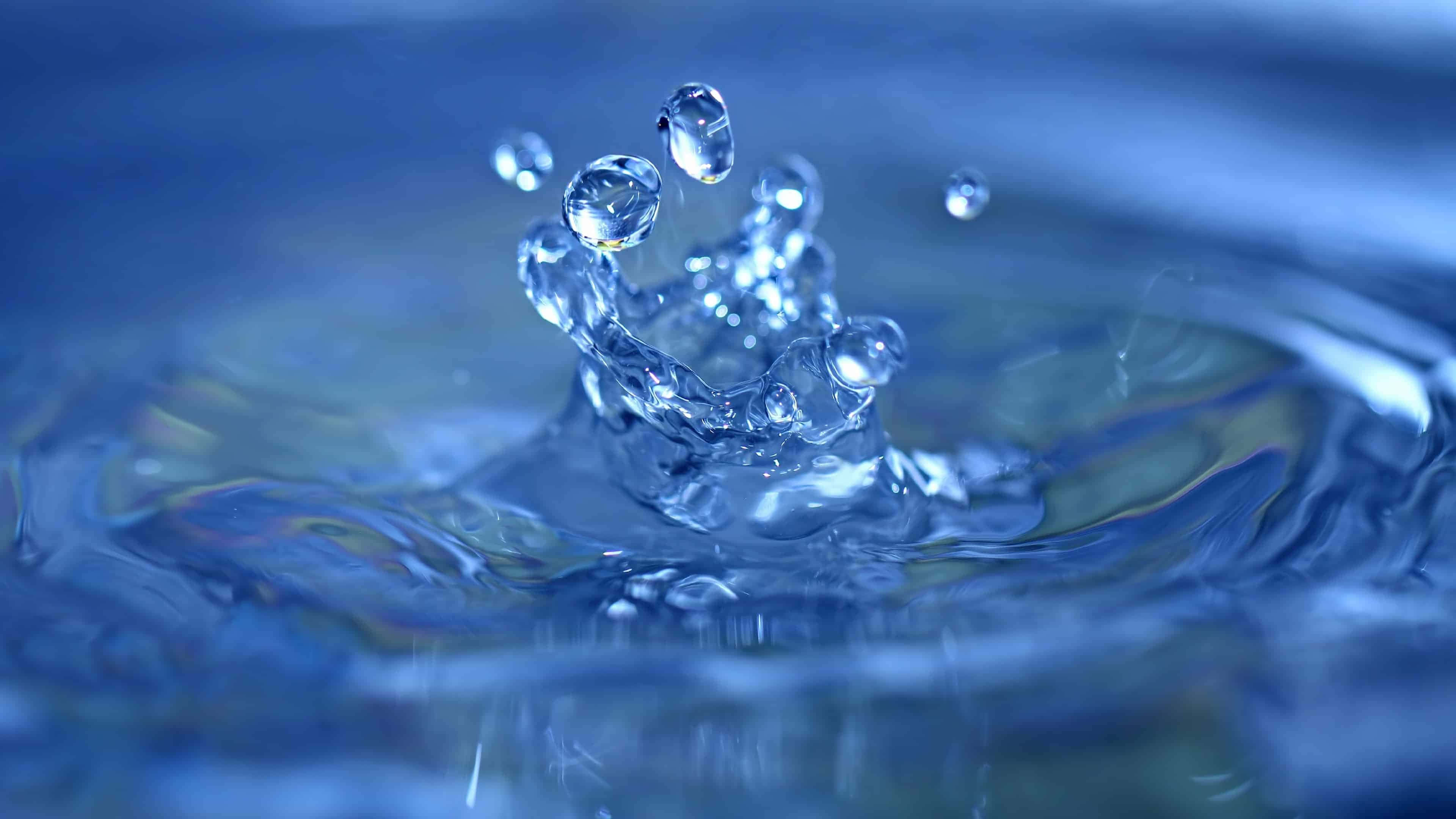 Ripples 桌布 壁紙 — 晶瑩剔透的水滴皇冠在深藍色液體背景上向上迸發。