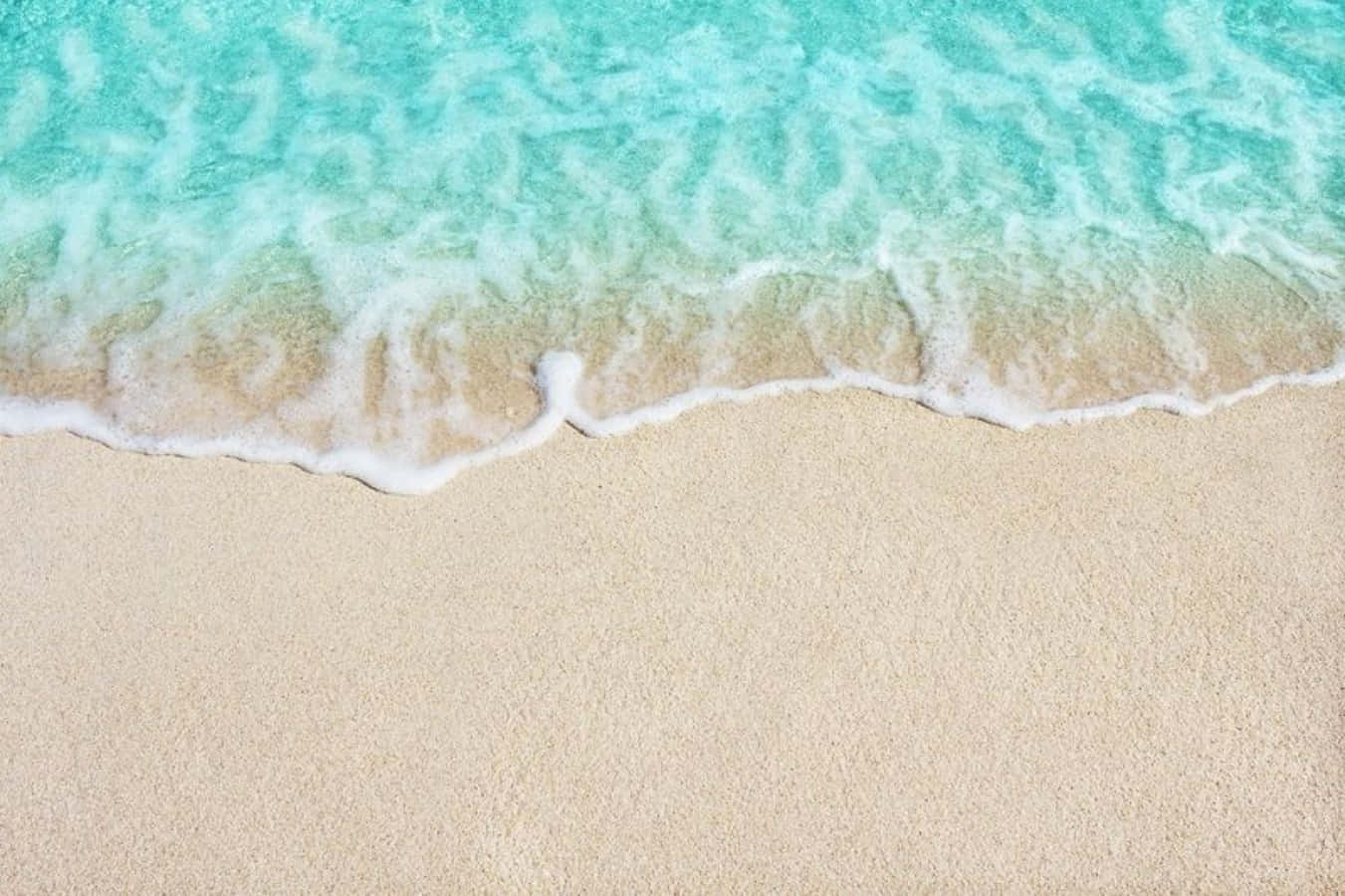 sand 桌布 壁紙 — 晶瑩剔透的碧綠海浪輕輕拍打著柔軟的淺色沙灘，呈現寧靜的熱帶海灘景象。