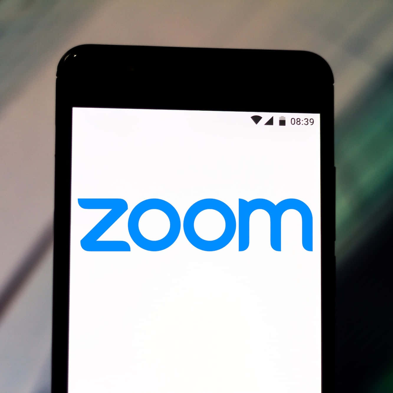 智慧型手機在白色螢幕上顯示 Zoom 應用程式標誌，時間為 08:39。 — 放大 壁紙