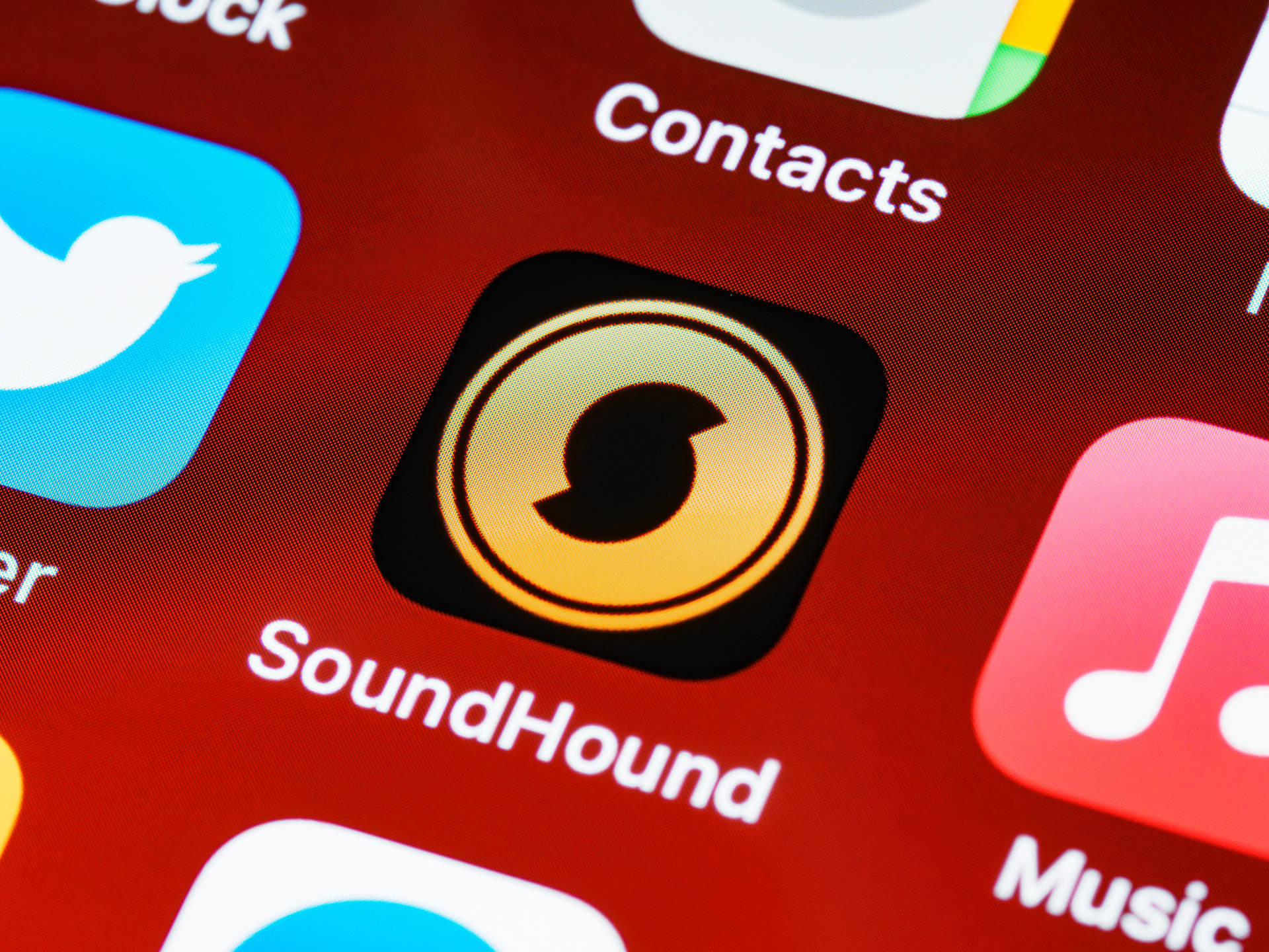 智慧型手機螢幕特寫，顯示 SoundHound 應用程式圖標。 — iPhone 14 壁紙