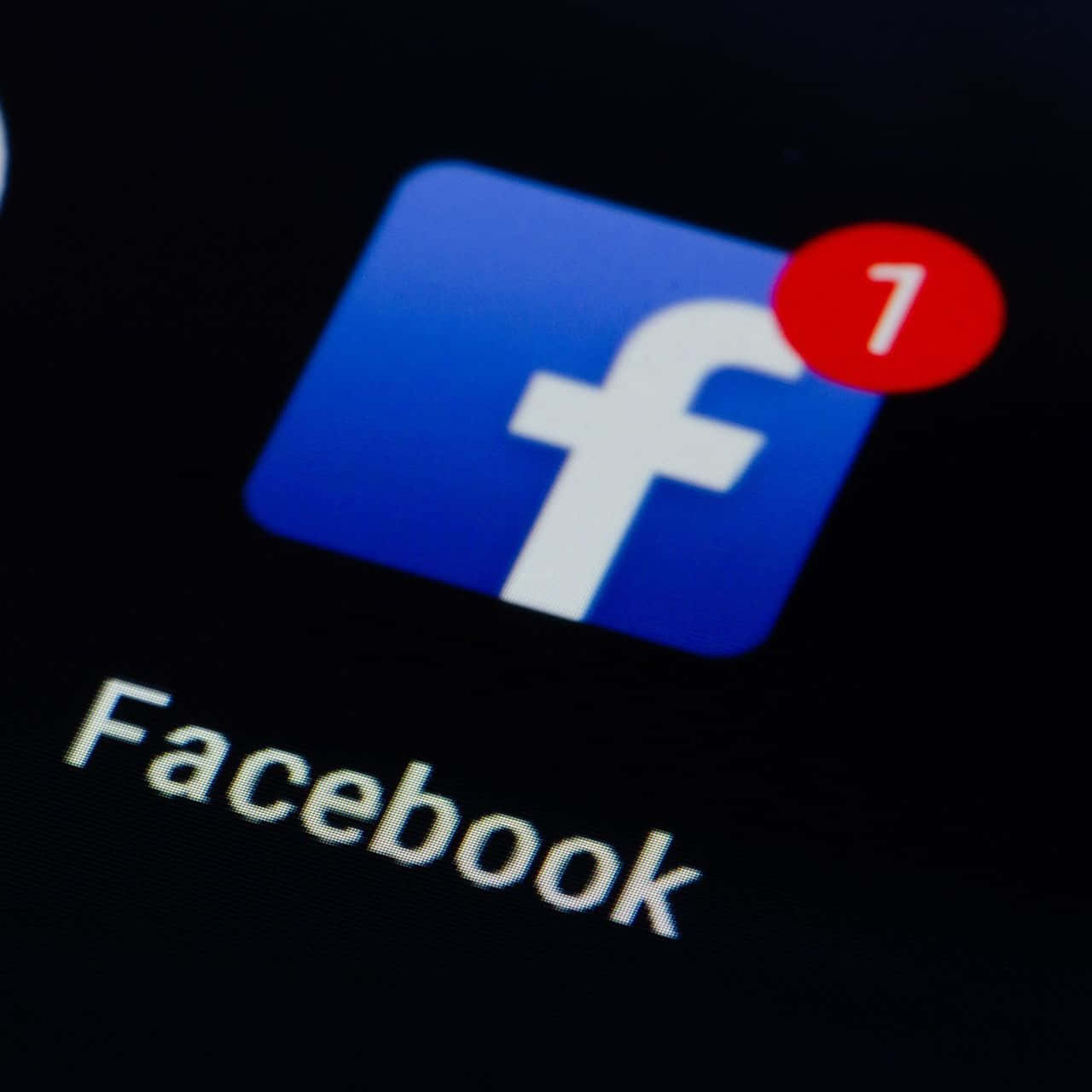 Facebook 桌布 壁紙 — 智慧型手機螢幕特寫，顯示Facebook應用程式圖示，帶有紅色通知徽章，顯示數字一。