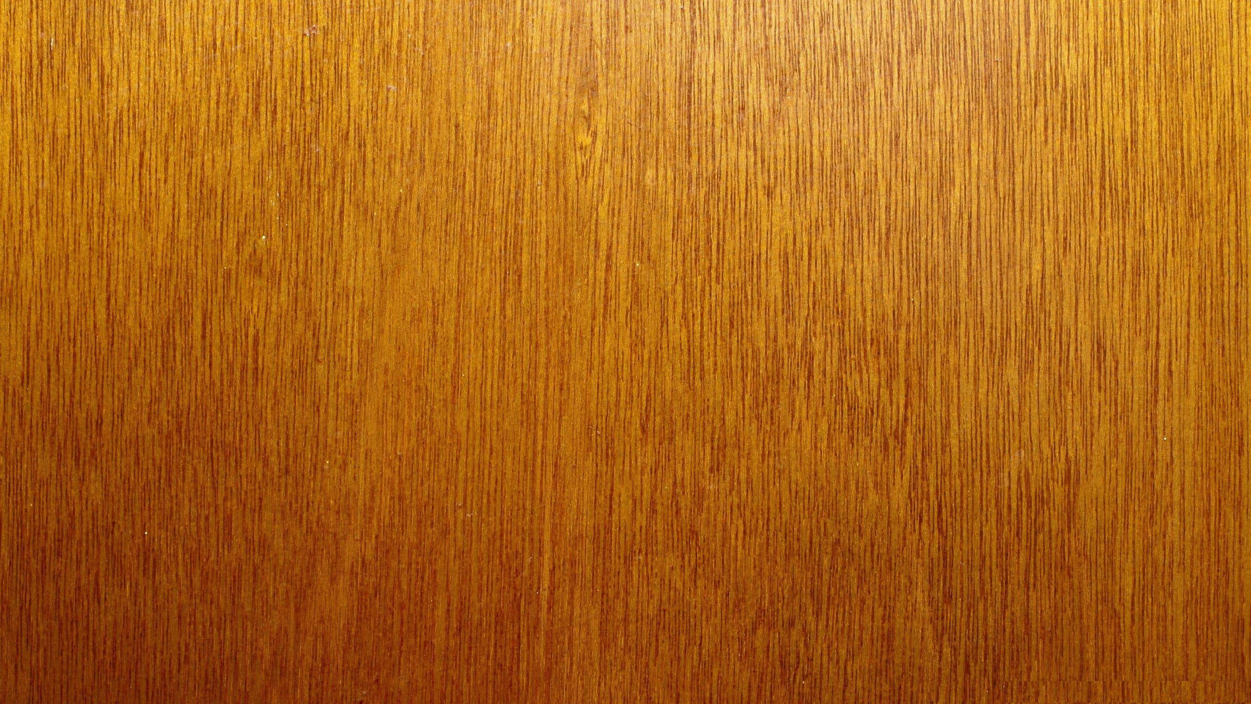 Mahogany 桌布 壁紙 — 暖光下豐富金棕色木紋的特寫，帶有垂直線條和細微節疤。