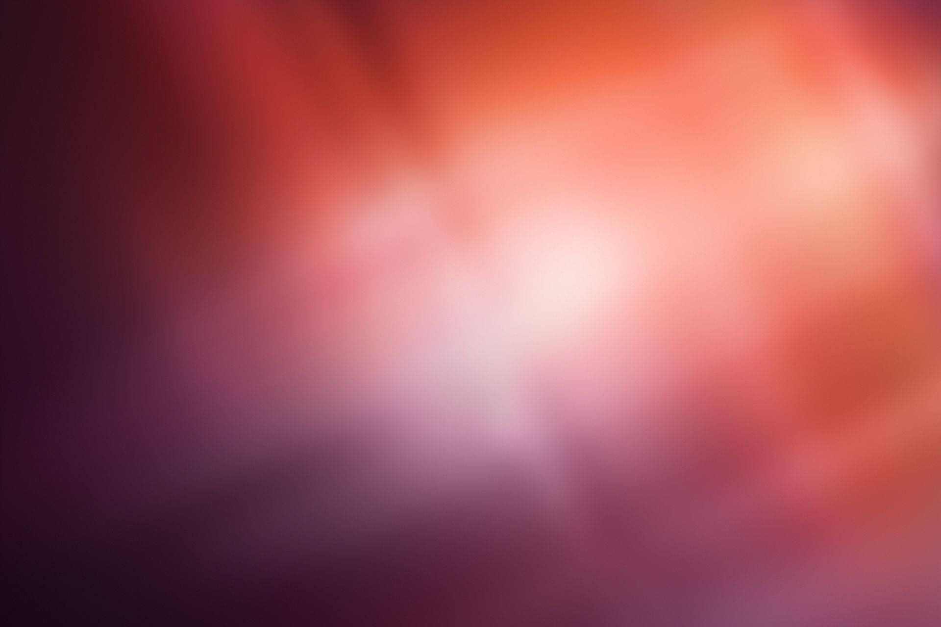 ubuntu 桌布 壁紙 — 暖紅色和紫色的柔和漸變，融合成一個帶有微妙光線的發光中心。