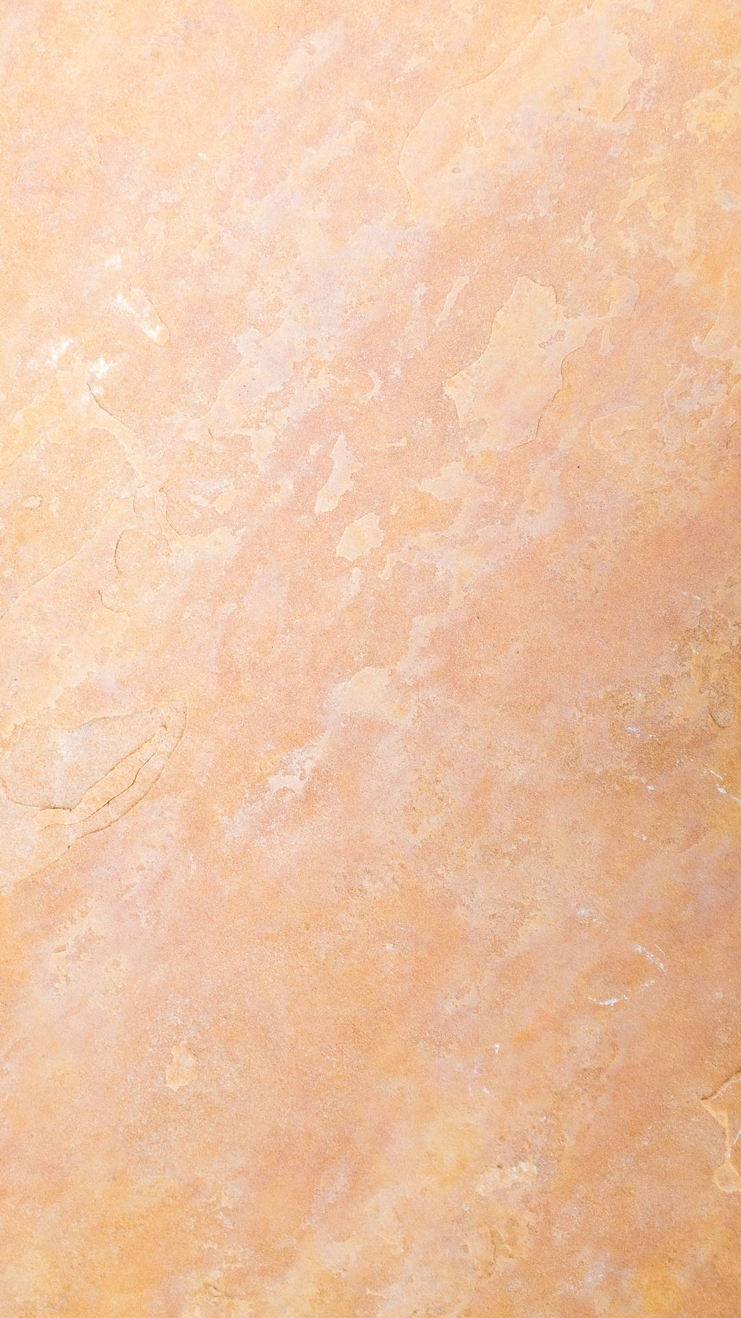 Beige Minimalist 桌布 壁紙 — 暖色調蜜桃色和奶油色紋理牆壁的特寫，帶有細微裂縫和不均勻表面。