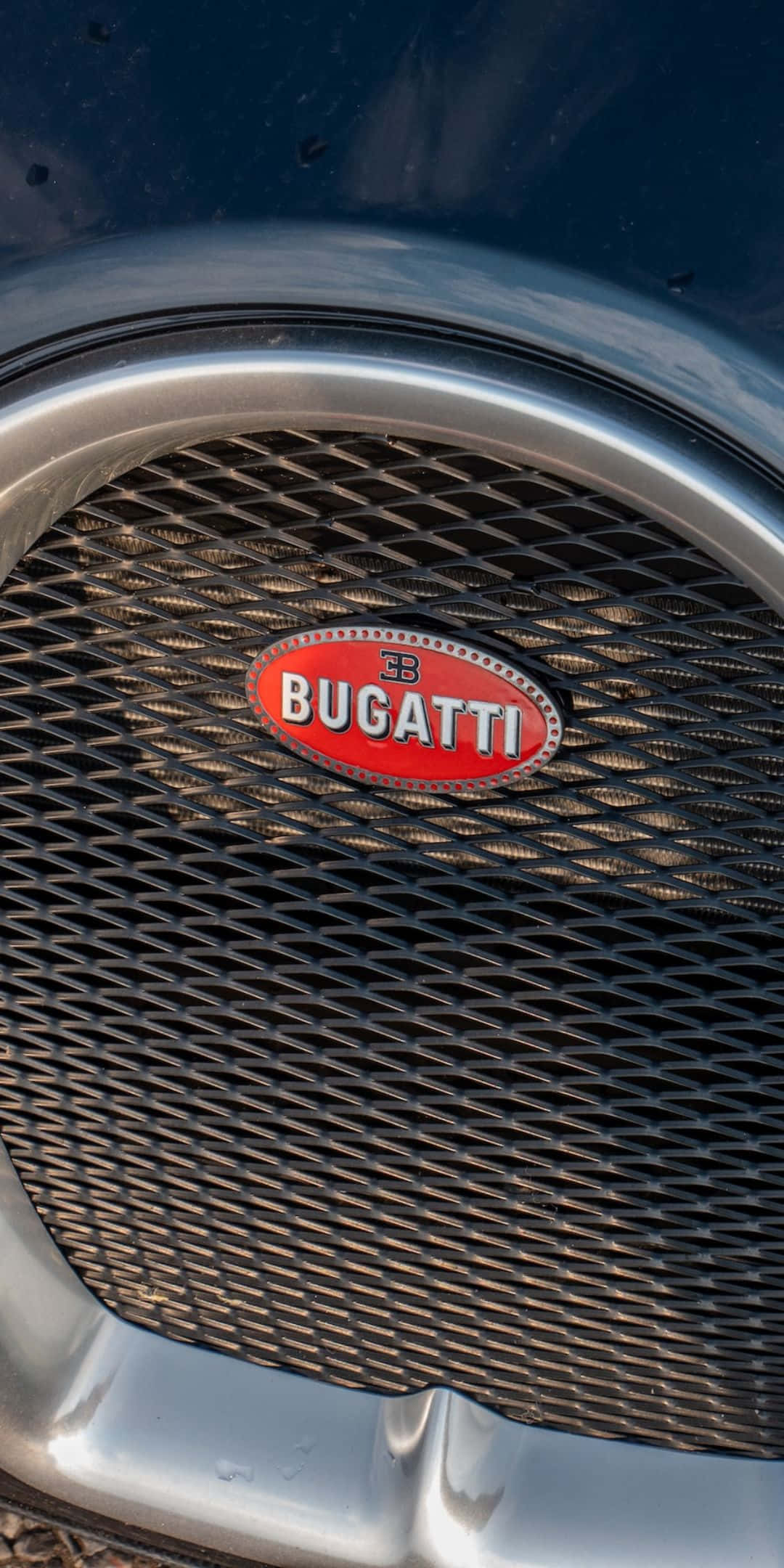 Best Bugatti 桌布 壁紙 — 暖陽下經典Bugatti水箱護罩特寫，帶紅色橢圓標誌和鍍鉻飾條。