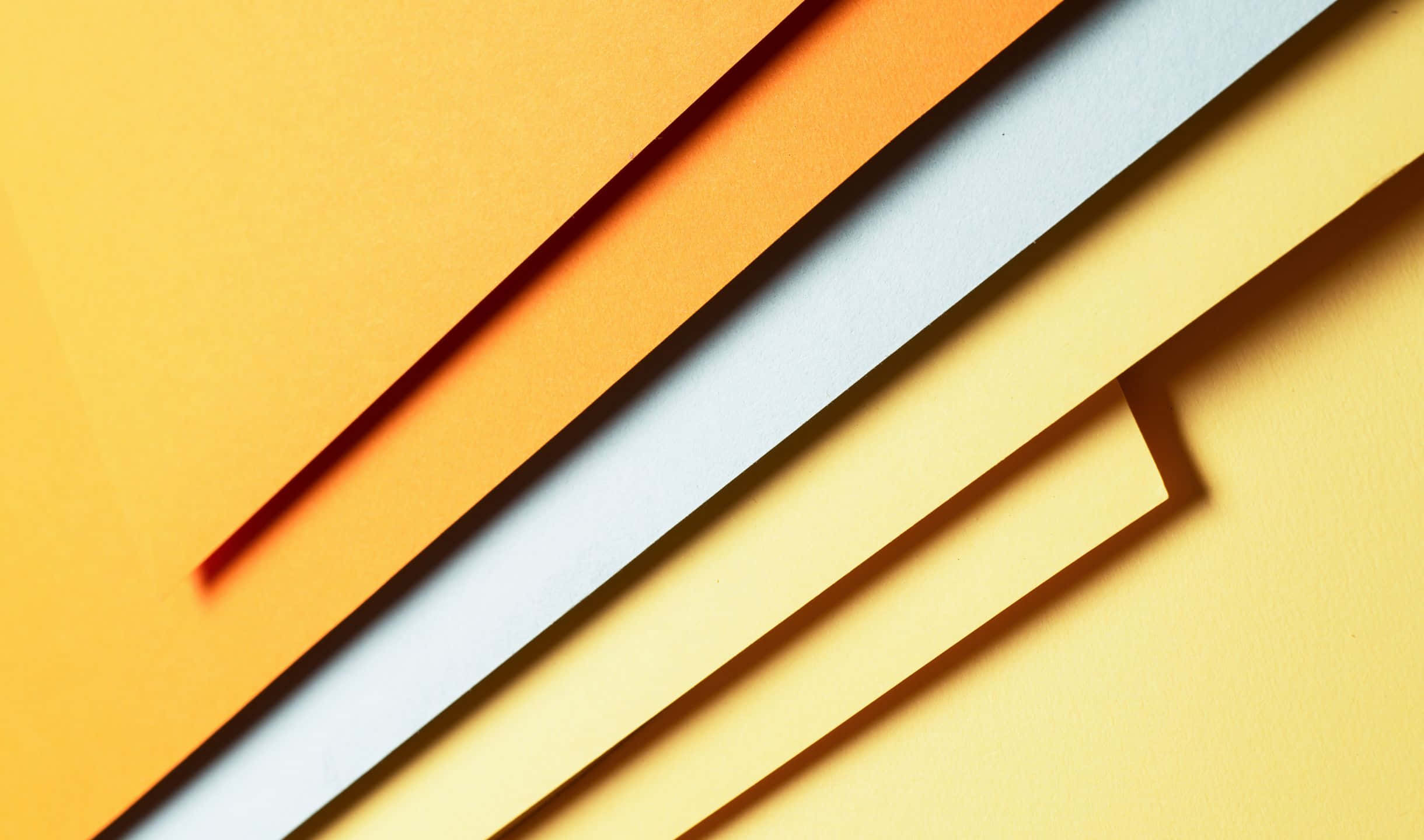 2440x1440 Material 桌布 壁紙 — 暖黃色和冷白色紙張的斜條紋，營造出帶有柔和陰影的大膽幾何構圖。